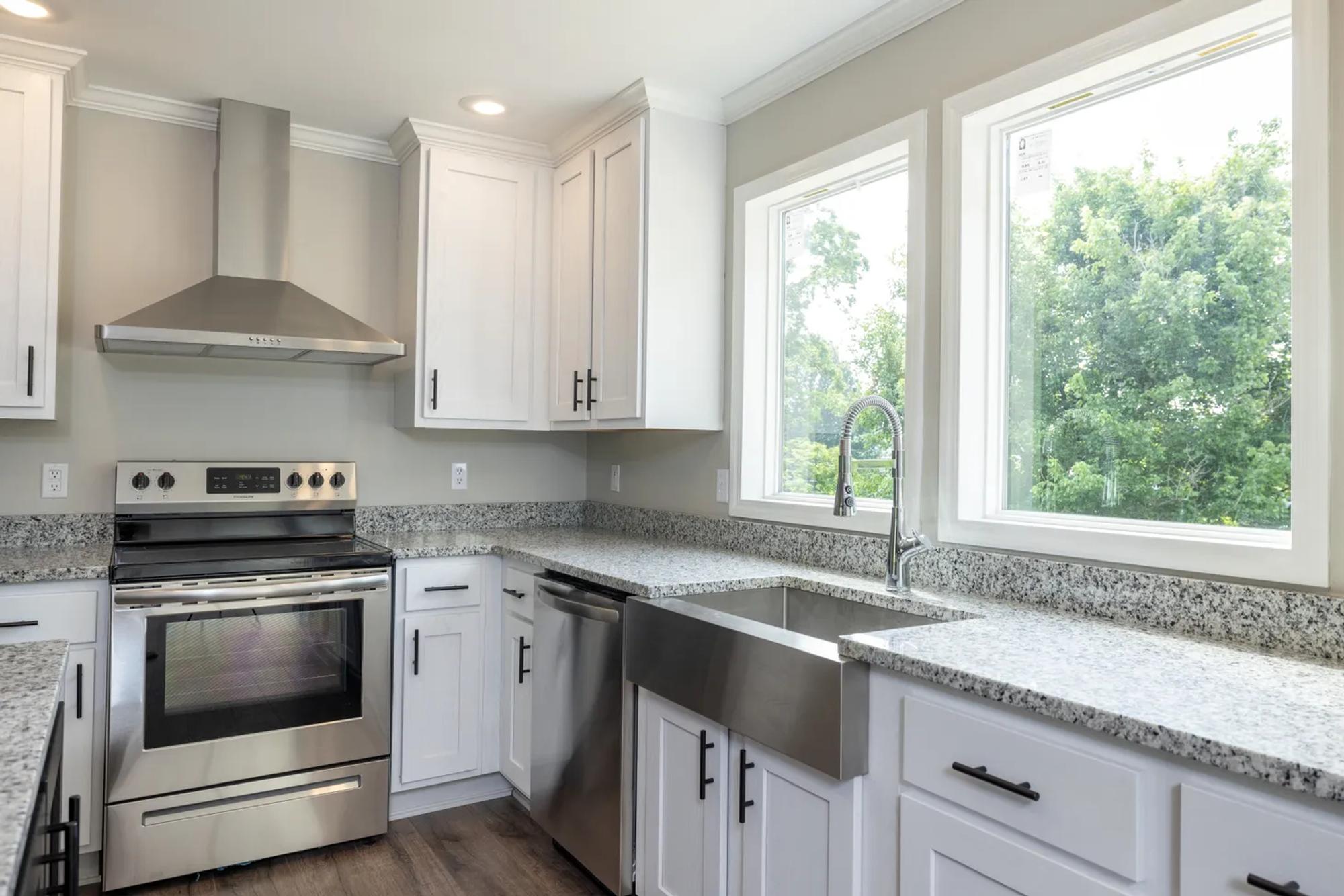 Kitchen with farmhouse sink and black-and-white speckled countertop