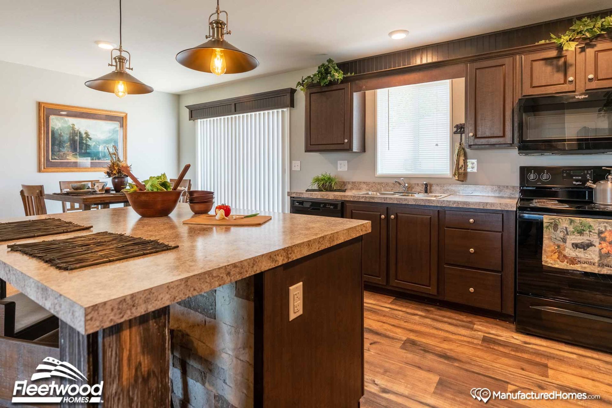 Large kitchen area with an island and brown cabinetry.