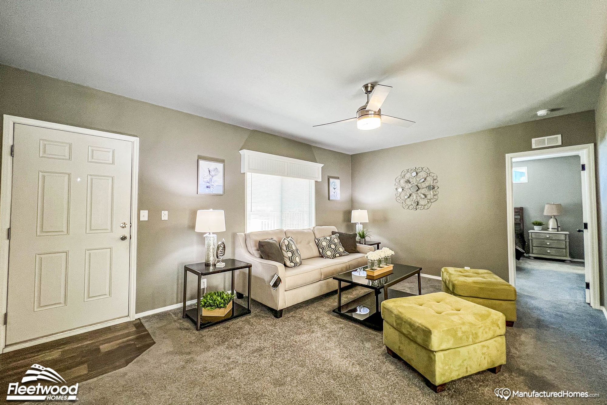 Large front room with a couch and two ottomans.