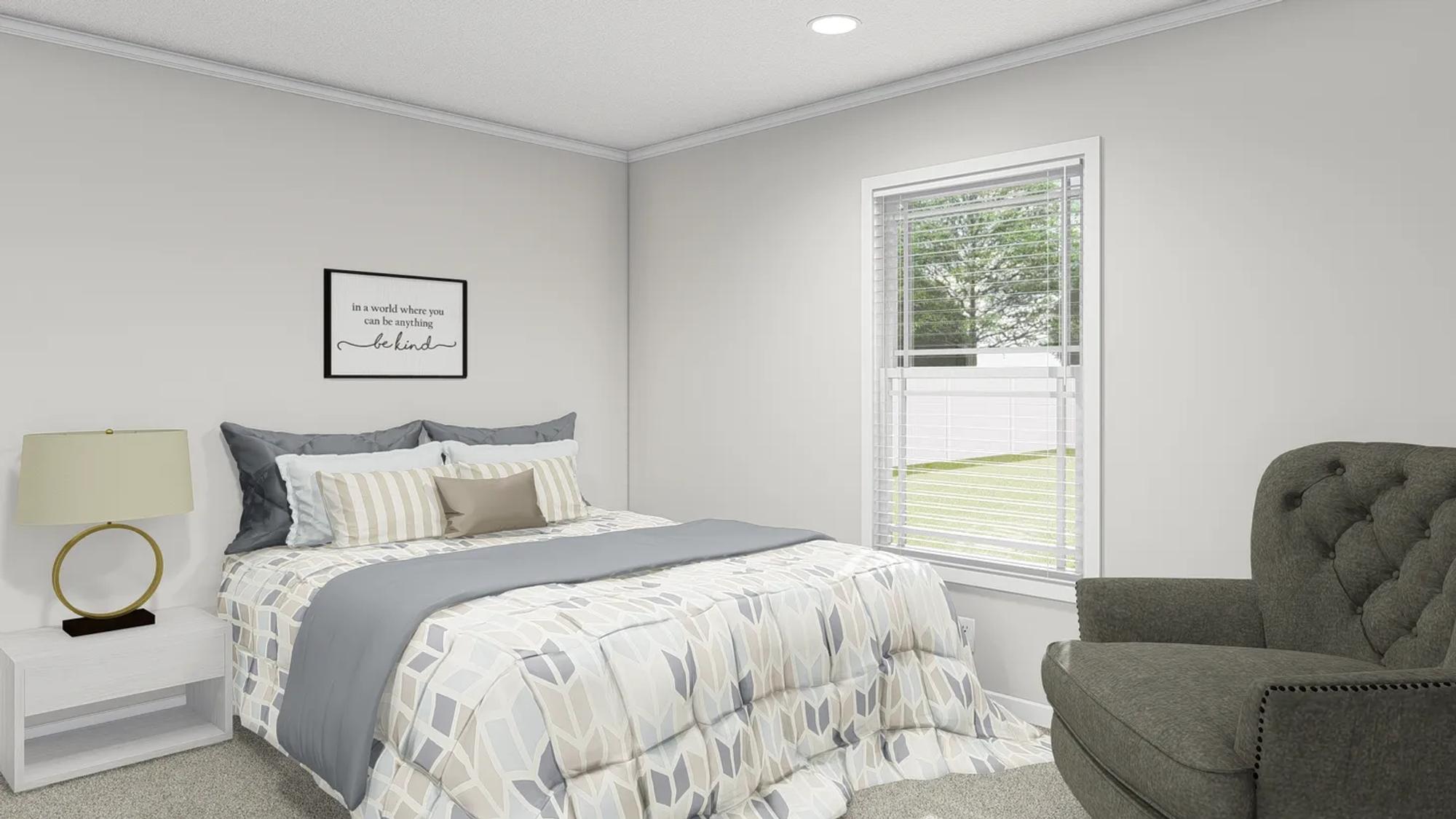 Bedroom with side table and lamp, chair, patterned bedspread, and a framed quote picture above the bed