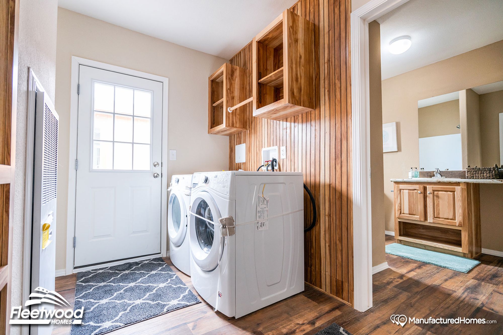 Laundry room section with wood-lined walls and a door providing access to the outside.