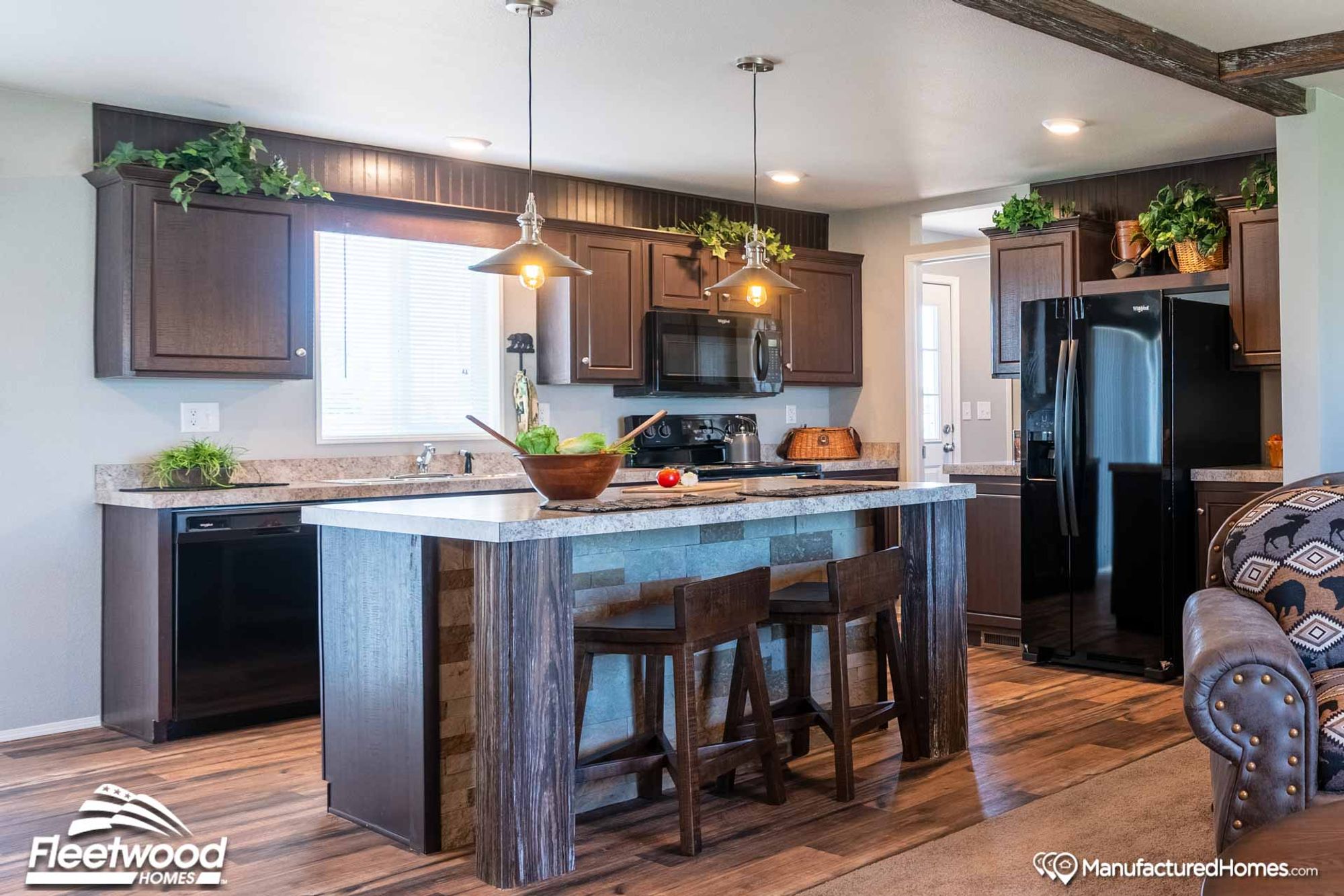 Large kitchen area with an island and brown cabinetry.