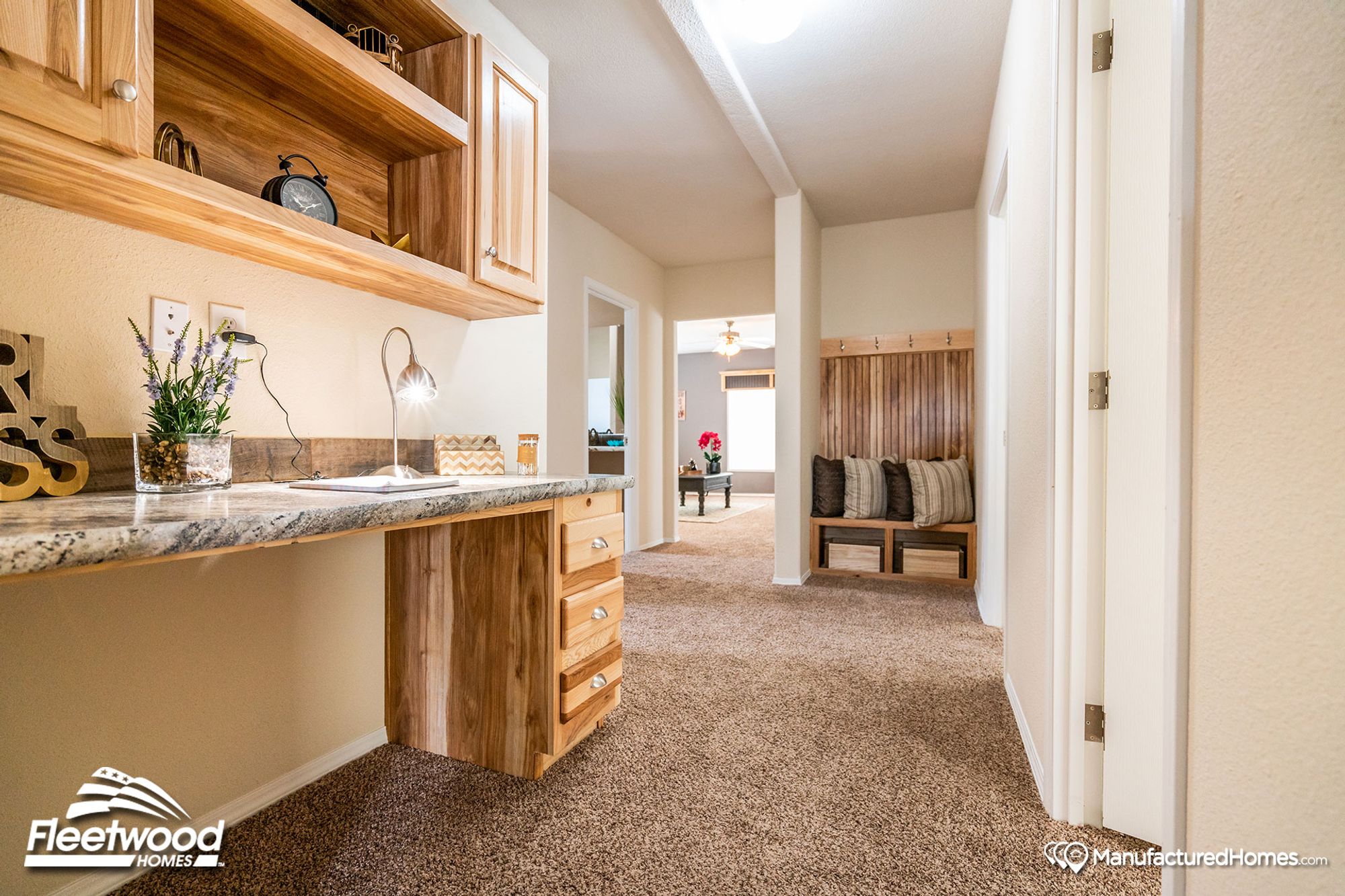 Large hallway with a built-in desk and an alcove featuring a bench, hooks, and drawers.
