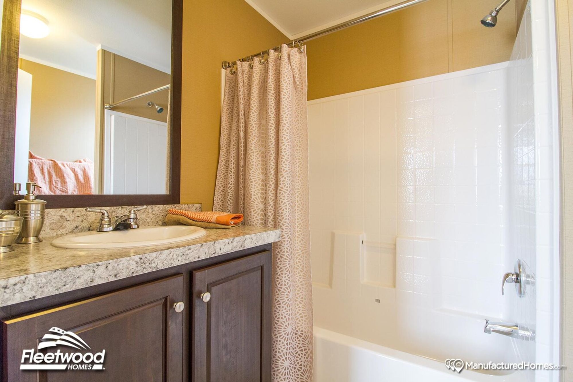 Bathroom with shower-tub combo, patterned curtain, toilet, and vanity with granite-style countertop.