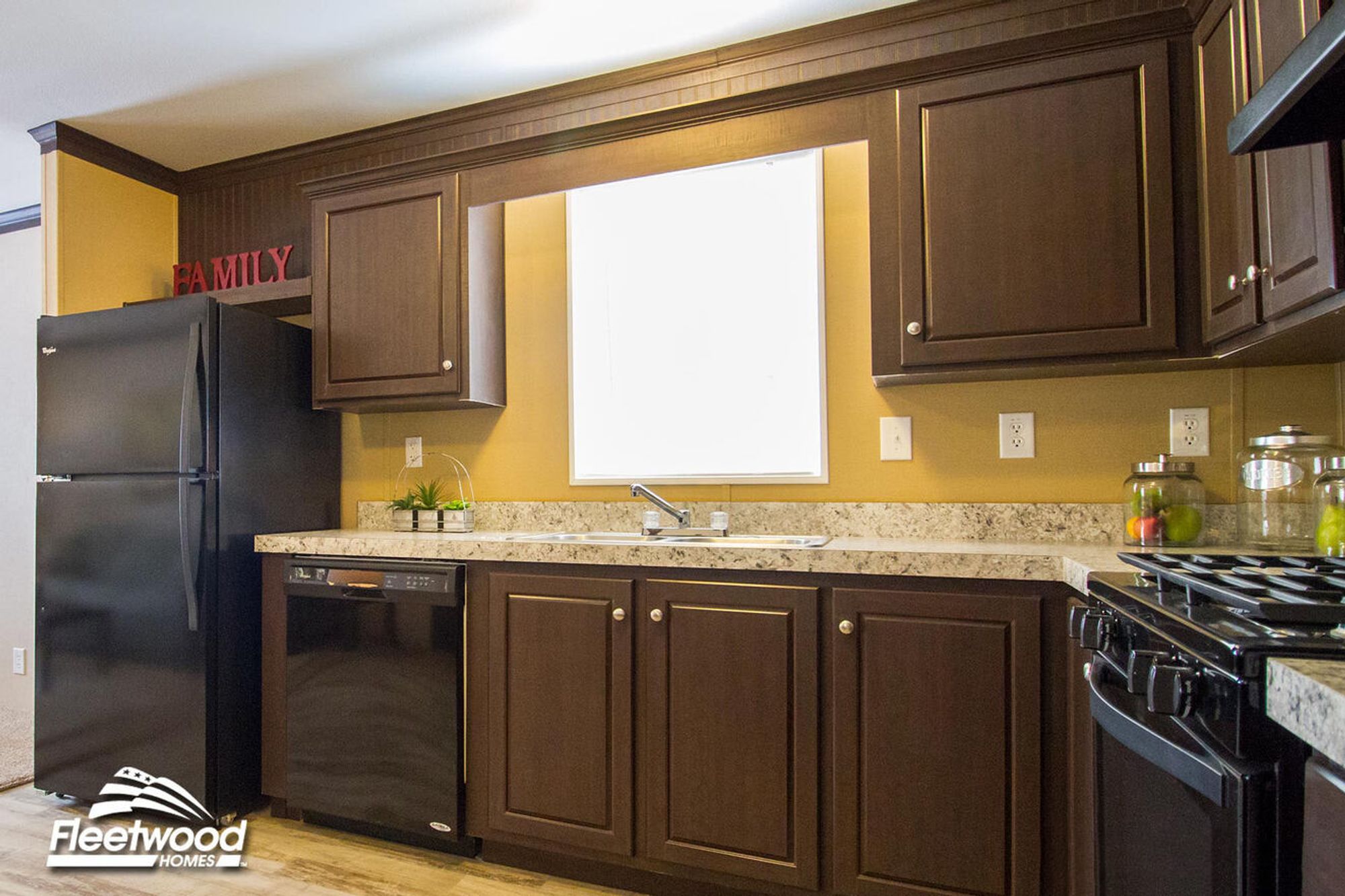 Kitchen with dark brown cabinets, granite-style countertops, black appliances, and a window above the sink.