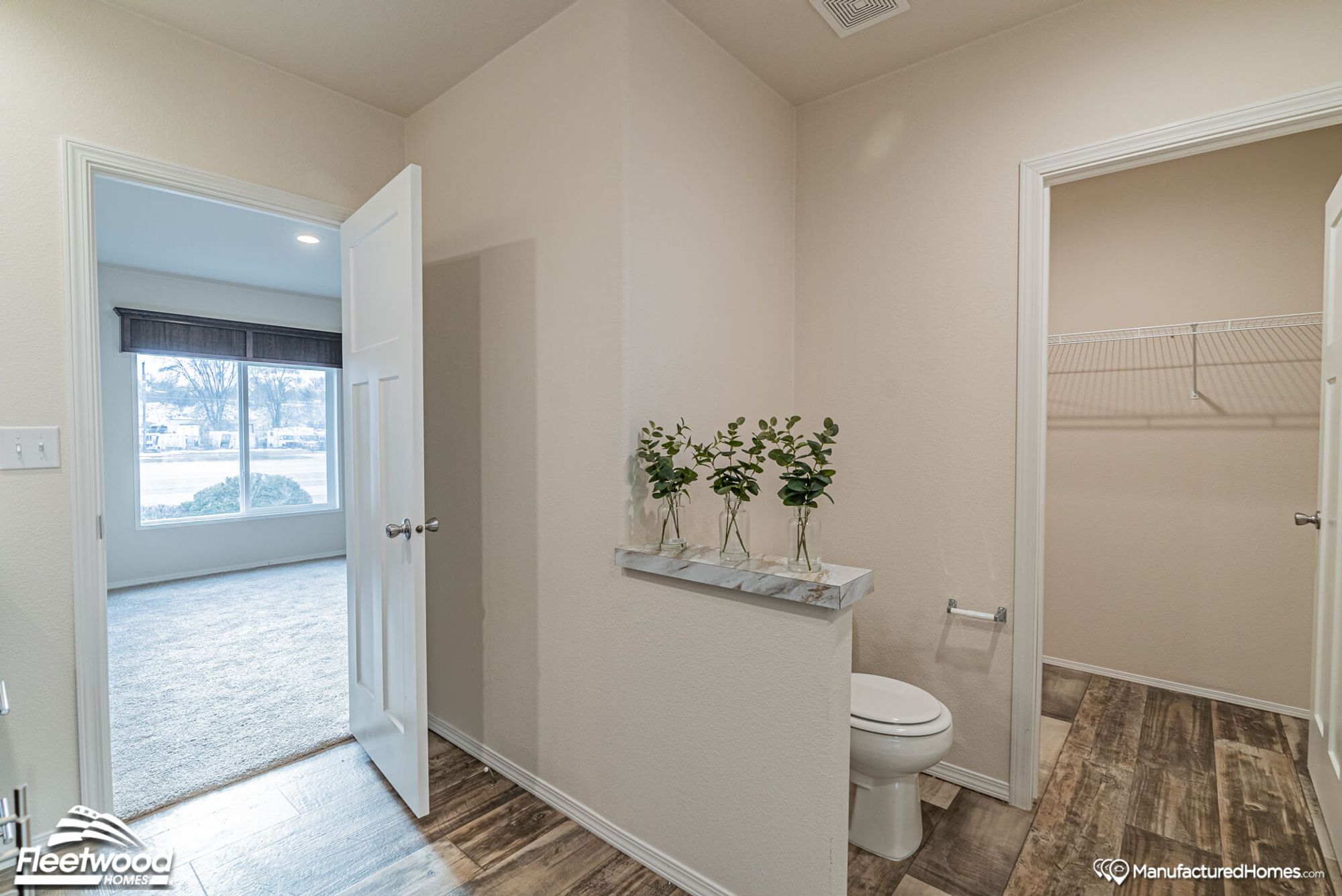 Large bathroom with a peek of a walk-in closet.