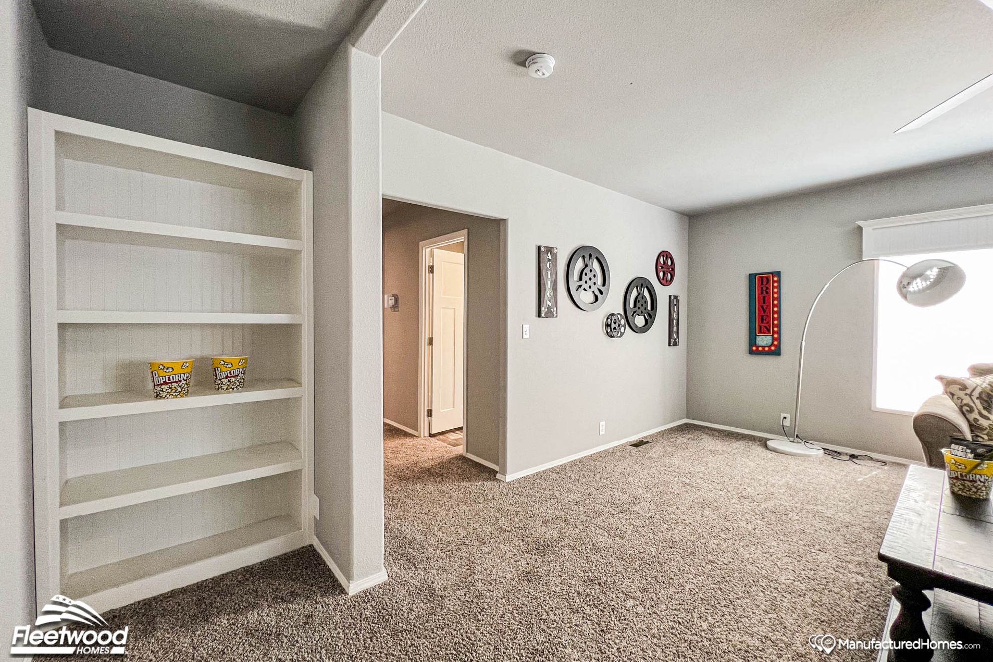Front room with a partial view of the coffee table and a small alcove featuring a large bookcase.