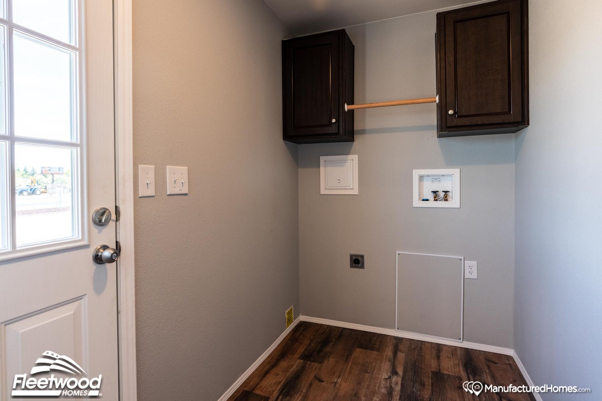 Laundry room with upper cabinets and washer and dryer hookups.