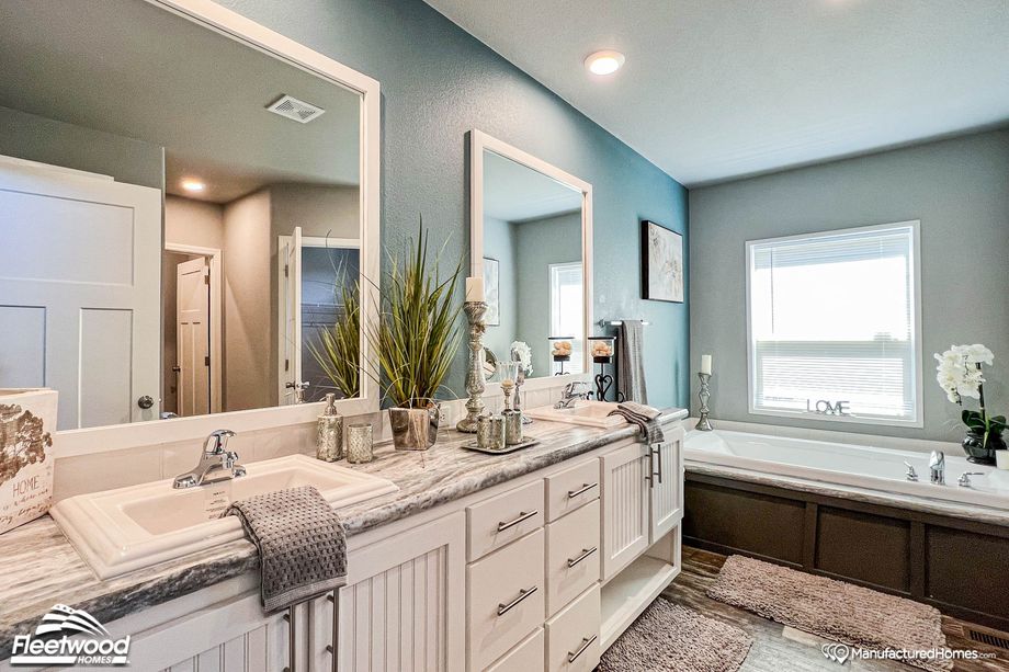 Close-up of a bathroom with a large bathtub and a spacious double-sink countertop.