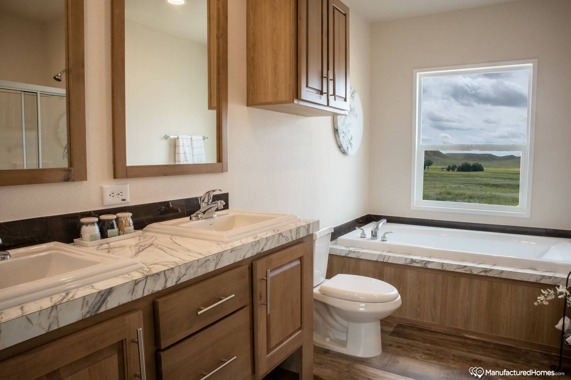 Close-up of a bathroom with a large bathtub and a spacious double-sink countertop.