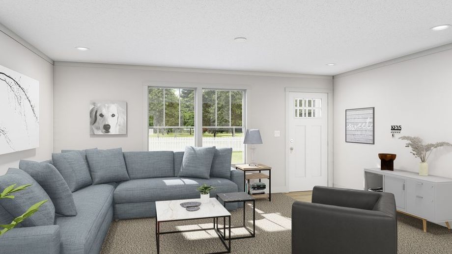 Living room interior with large windows, gray sectional sofa, armchair, nested coffee tables, and neutral décor; natural light fills the space.