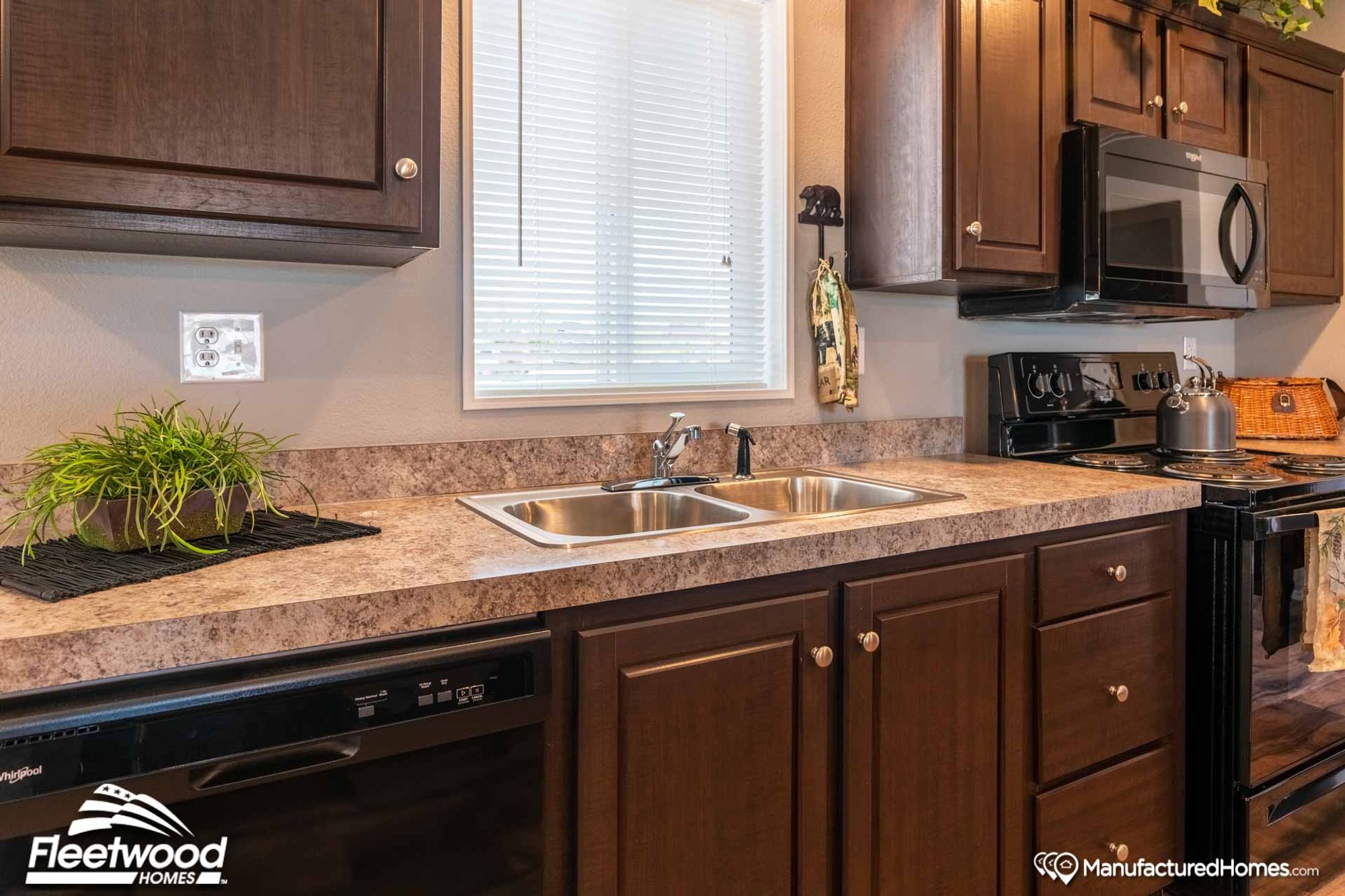 Close-up of the kitchen area, showcasing the sink, oven, and dishwasher.