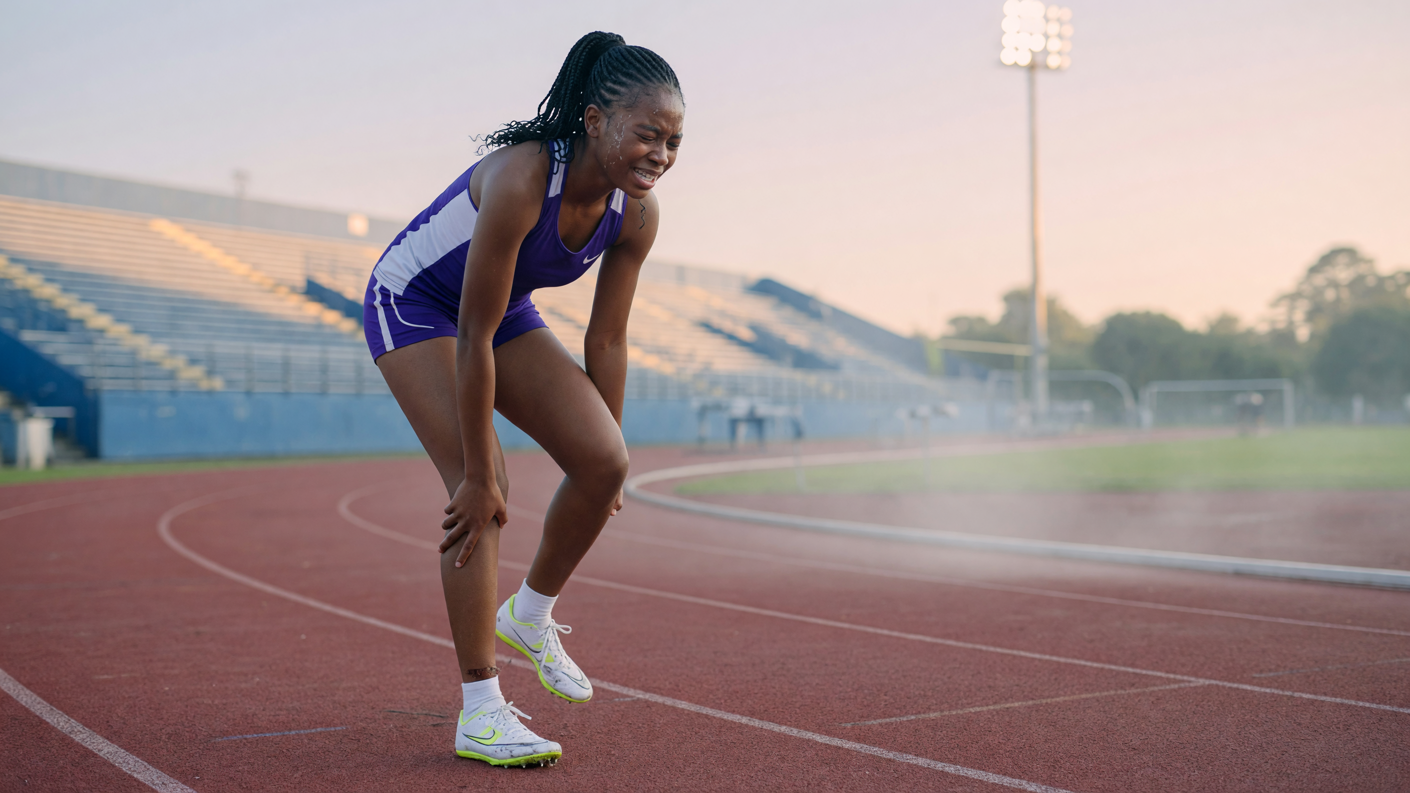 Athlete holding shin with early stress fracture symptoms during running