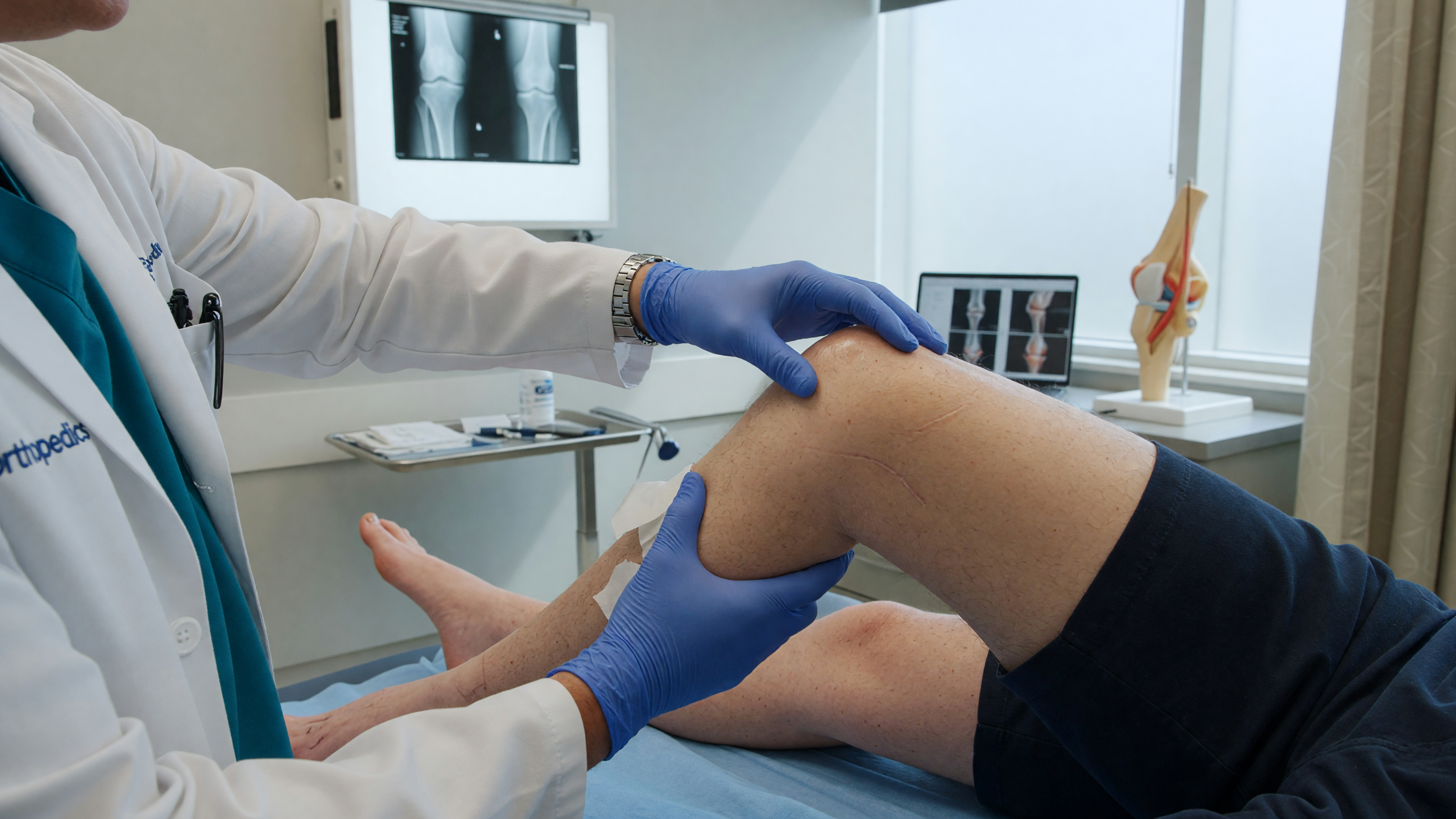 Doctor examining a patient's knee showing meniscus tear symptoms of a cartilage injury