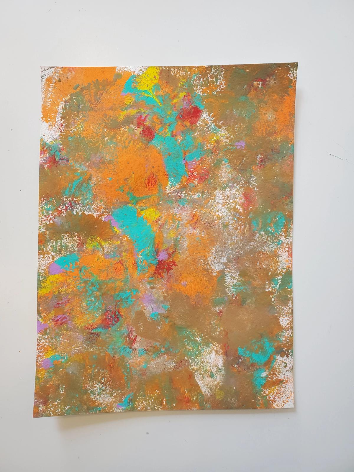 Overlapping layers of orange, ,teal, brown, red and purple paints dabbed with a sponge on the page