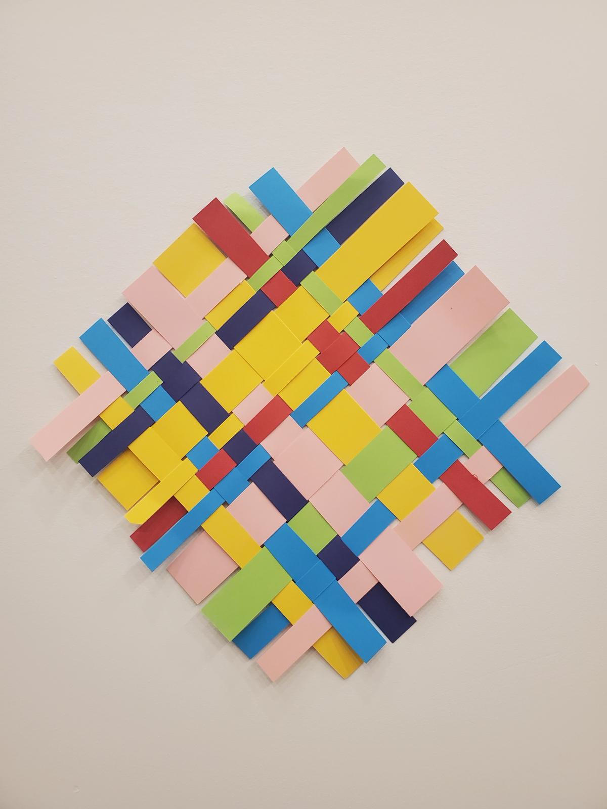 Colourful paper strips woven together in a square shape