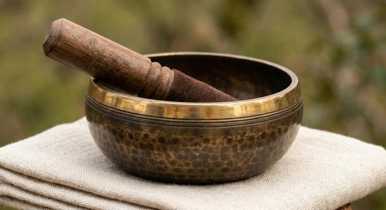 Bronze singing bowl and mallet on linen