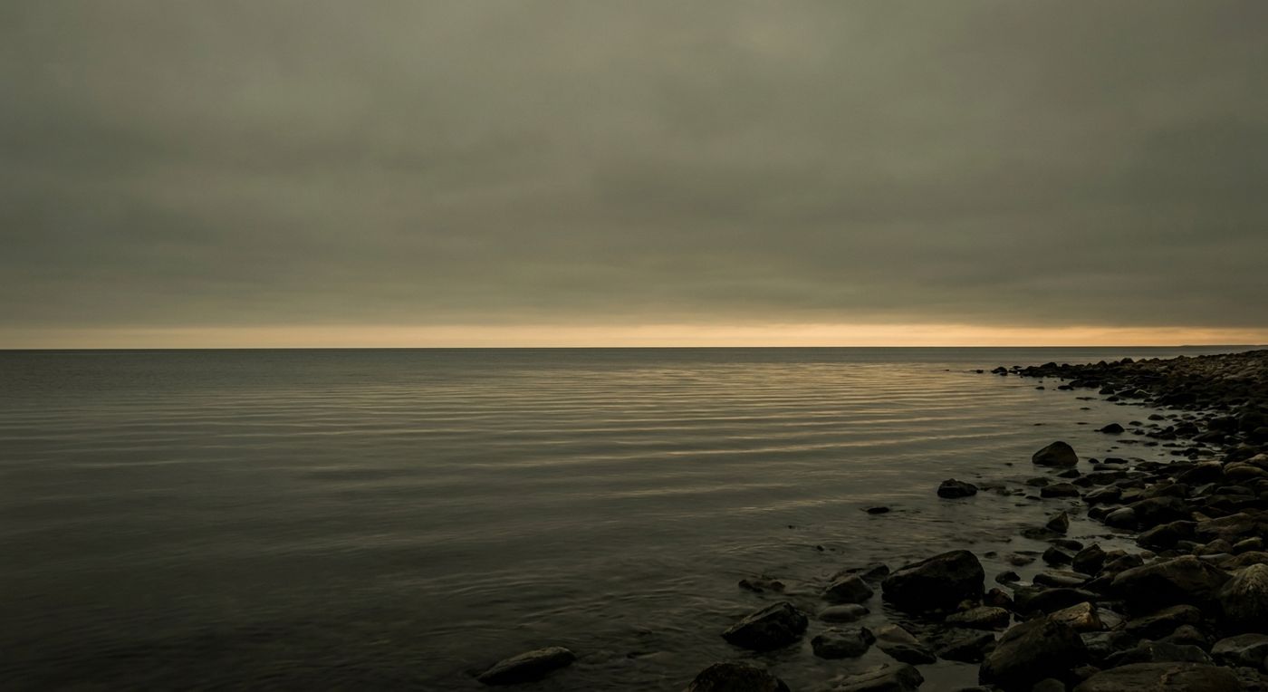 Calm sea at dusk with a gold horizon