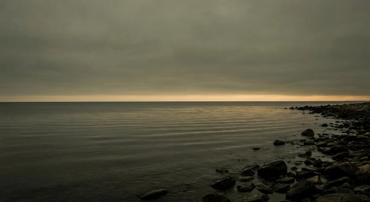 Calm sea at dusk with a gold horizon