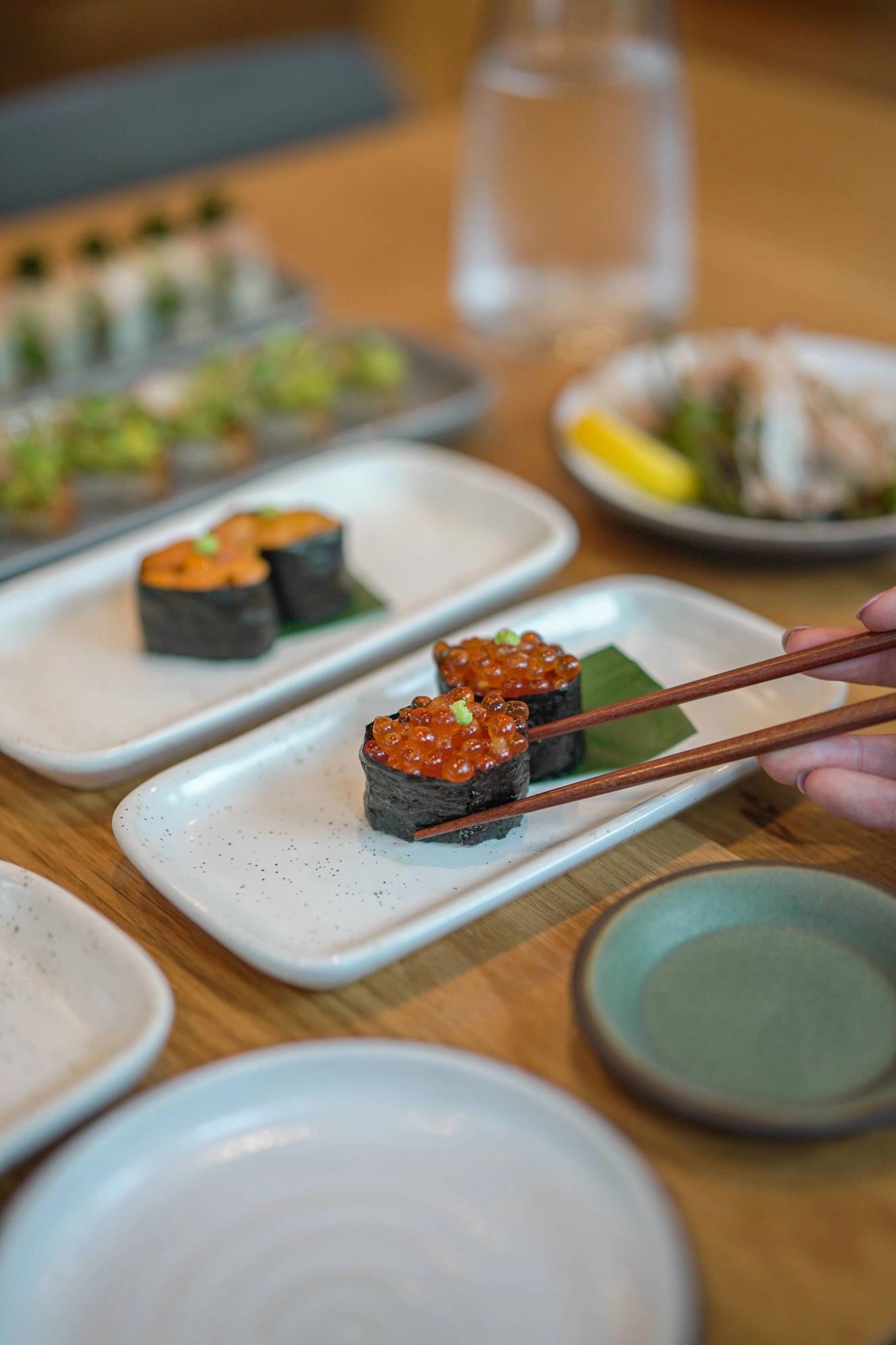 Uni nigiri and ikura nigiri on plates.