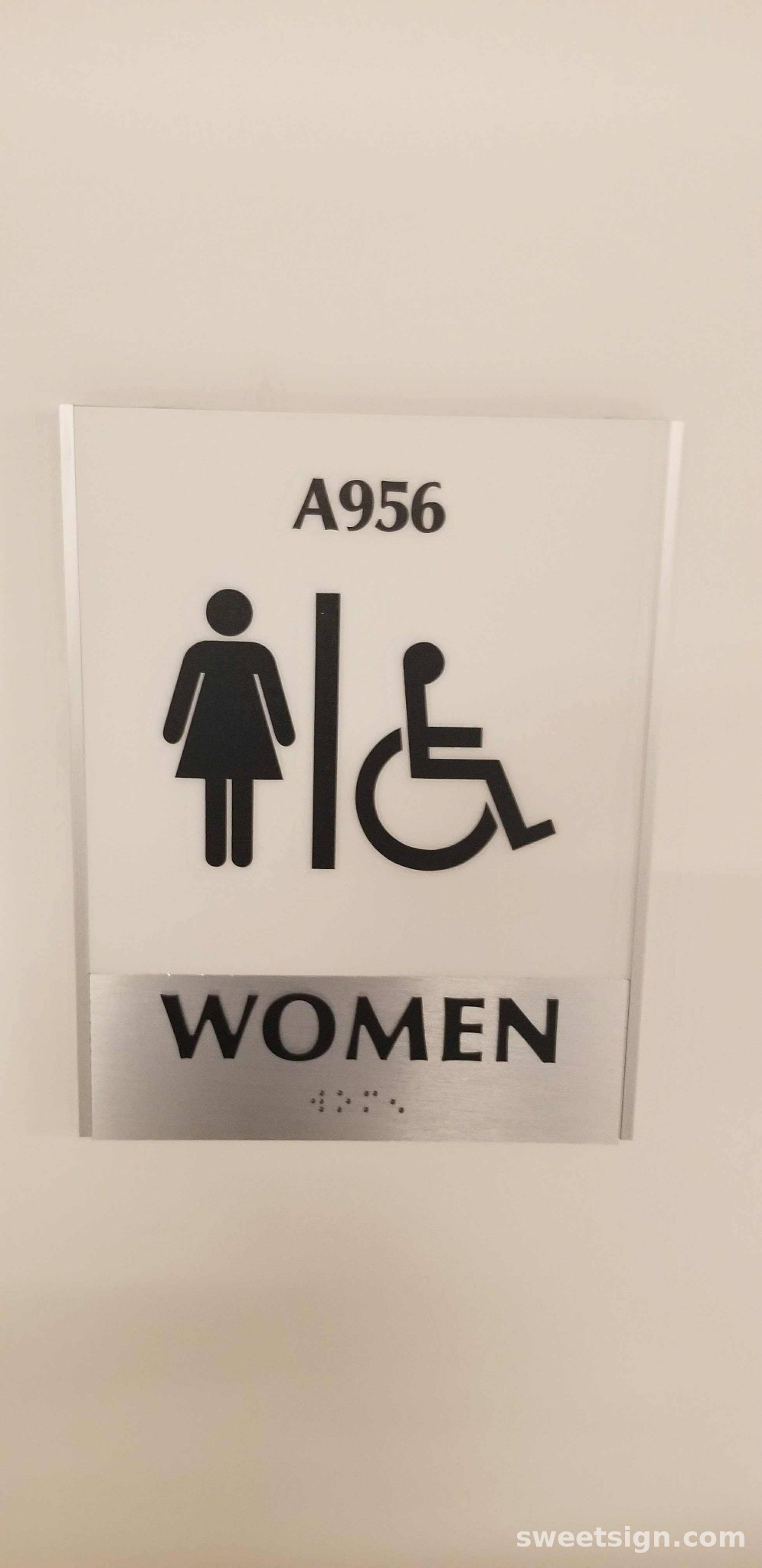 ADA compliant women’s restroom sign with wheelchair accessibility and braille