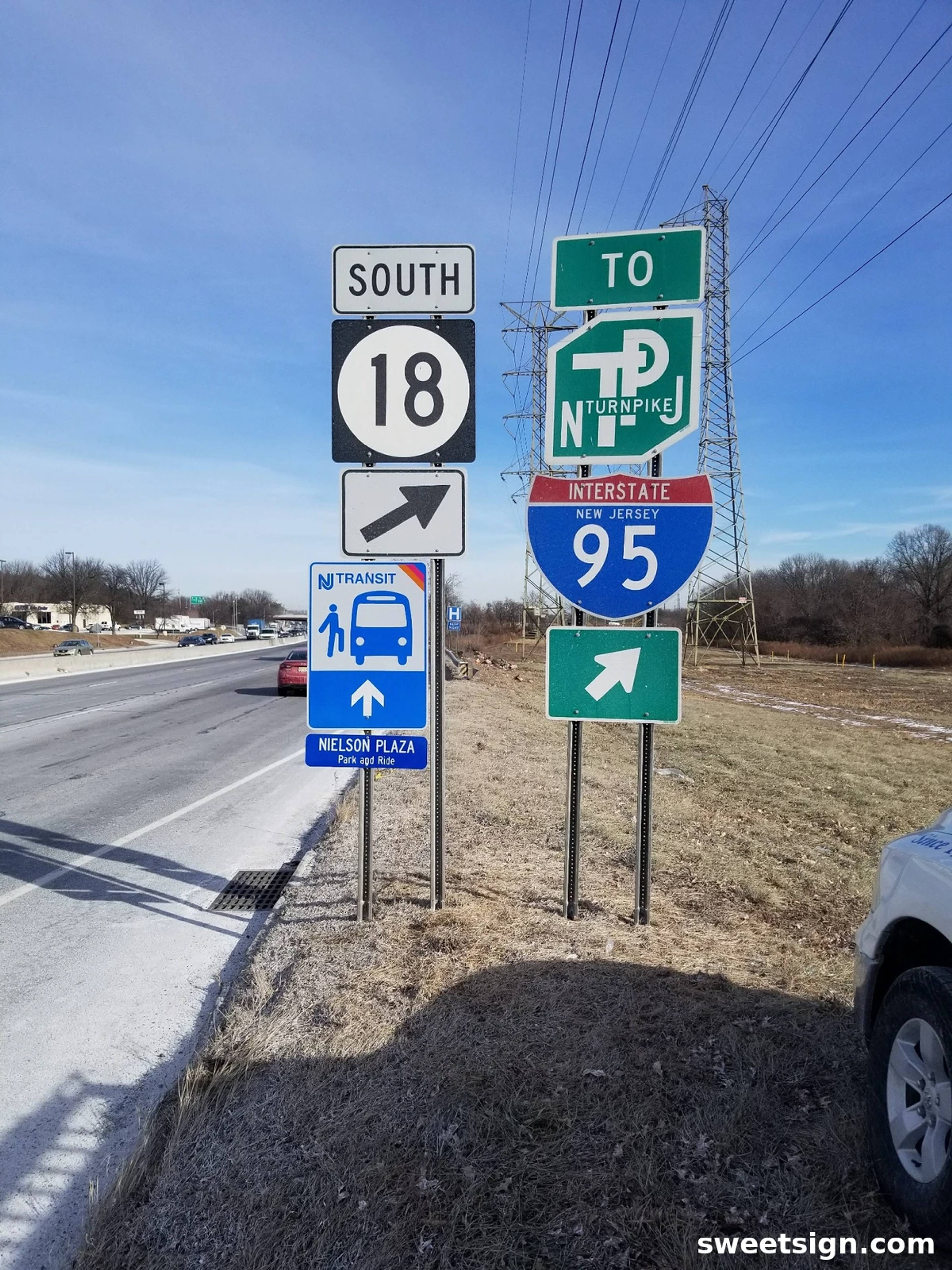 Interstate and state highway signage showing NJ Turnpike, I-95, and NJ Transit access. High-visibility reflective guide signs for traffic navigation.