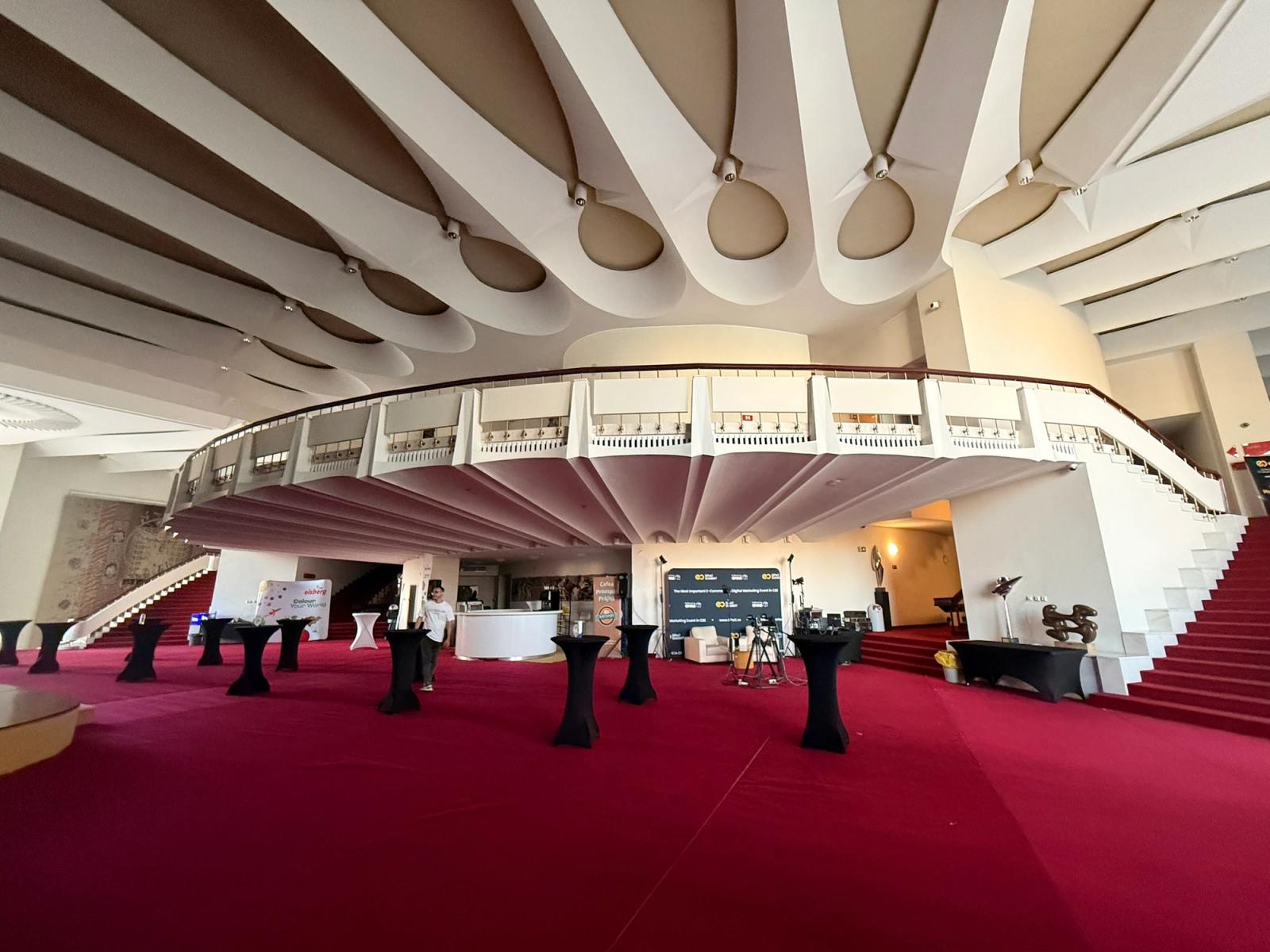 Foaierul Sălii Mari a Teatrului Național București la 06:39, pe 26 mai 2026, cu mesele înalte pregătite înainte de deschiderea GPeC EXPO.
