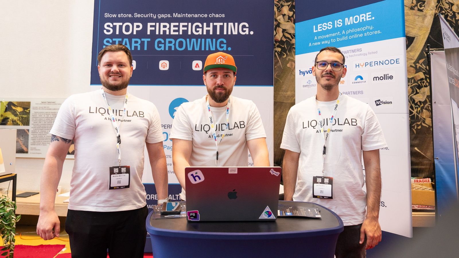 Echipa LIQUIDLAB la standul de la GPeC SUMMIT, 26 mai 2026, în fața bannerului Stop firefighting. Start growing. și a roll-up-ului Ask us about Hyvä.