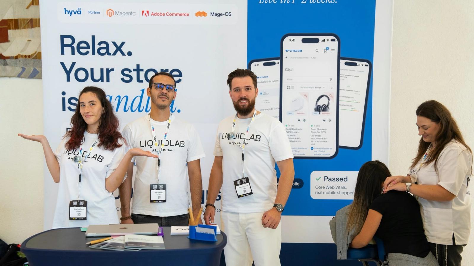 The LIQUIDLAB stand at GPeC SUMMIT 2026, with the Relax. Your store is handled. banner, three team members at the table and a visitor in the massage chair.