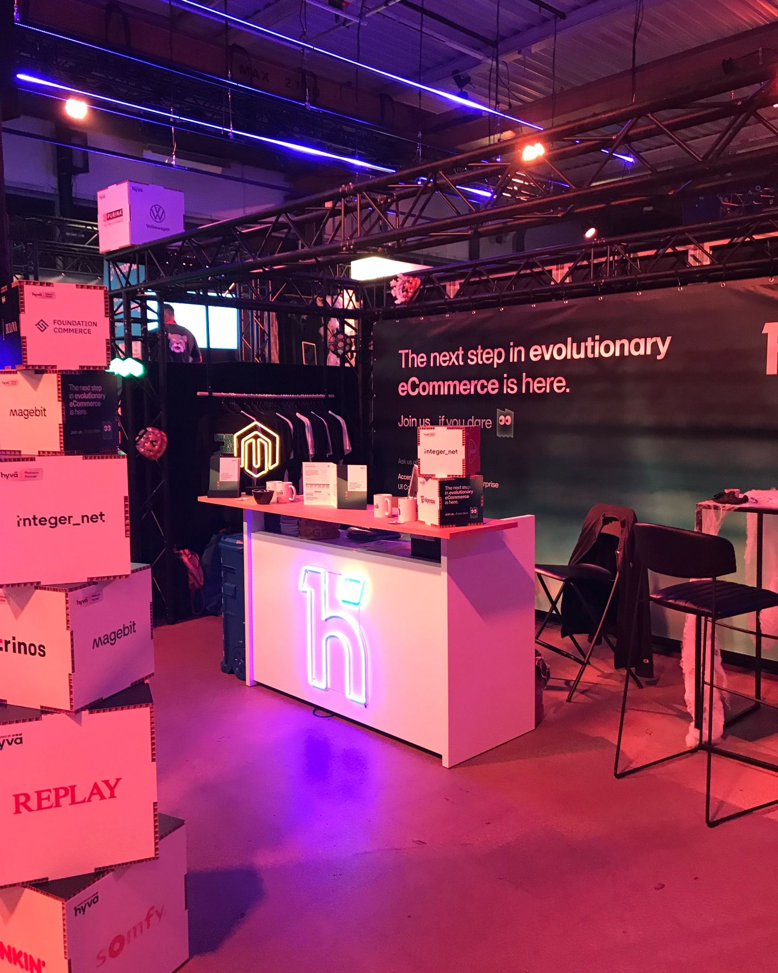 Standul Hyvä la Meet Magento Netherlands 2024, cu mesajul „The next step in evolutionary eCommerce is here.”