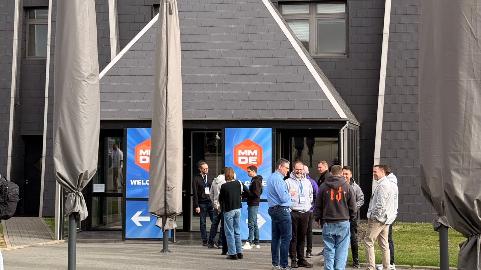 Intrarea în Pyramide Mainz în dimineața de 22 octombrie 2026, cu bannerele Meet Magento Germany pe uși și participanți afară.