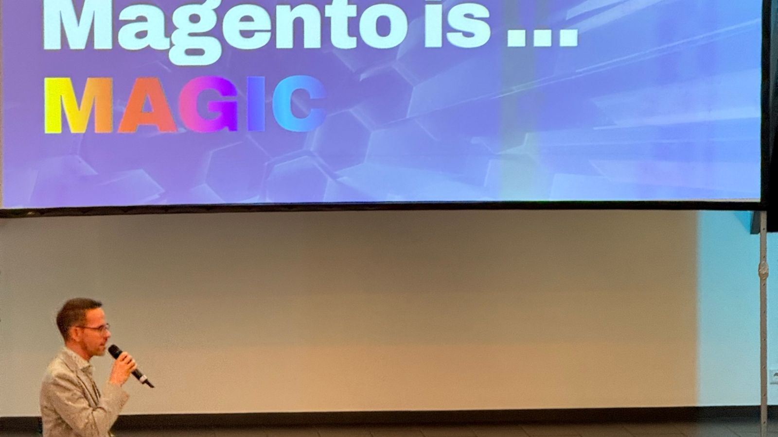 Prezentarea de final de la Meet Magento Germany 2026, cu textul „Magento is… MAGIC” pe ecranul mare.