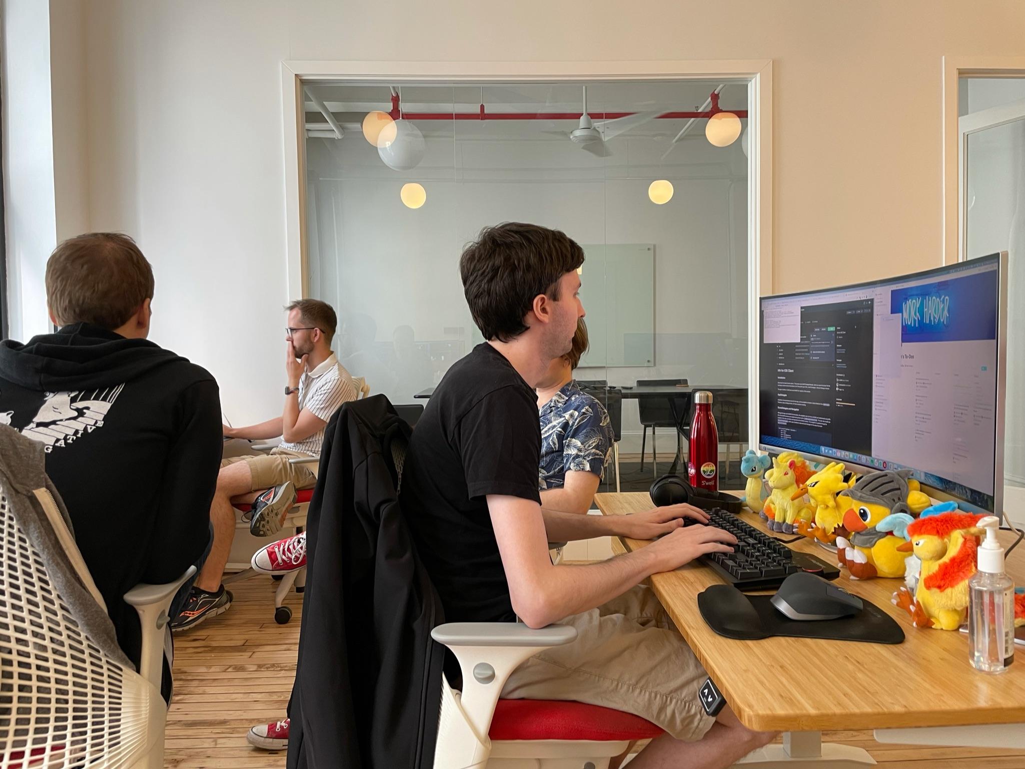 Michael Liberatore, Andrew Harrison, Michael Amundsen, and mb Bischoff sitting at their desks in the Lickability office.