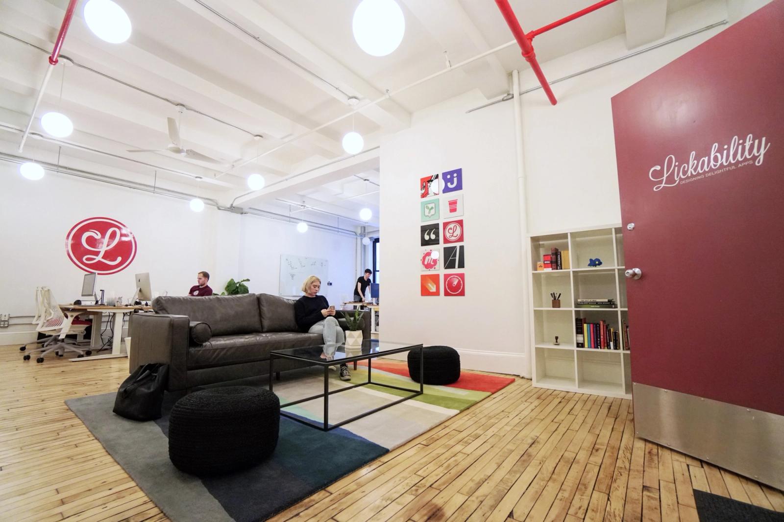 Wide shot of the Lickability office, with Jillian on the couch and engineers working in the background.