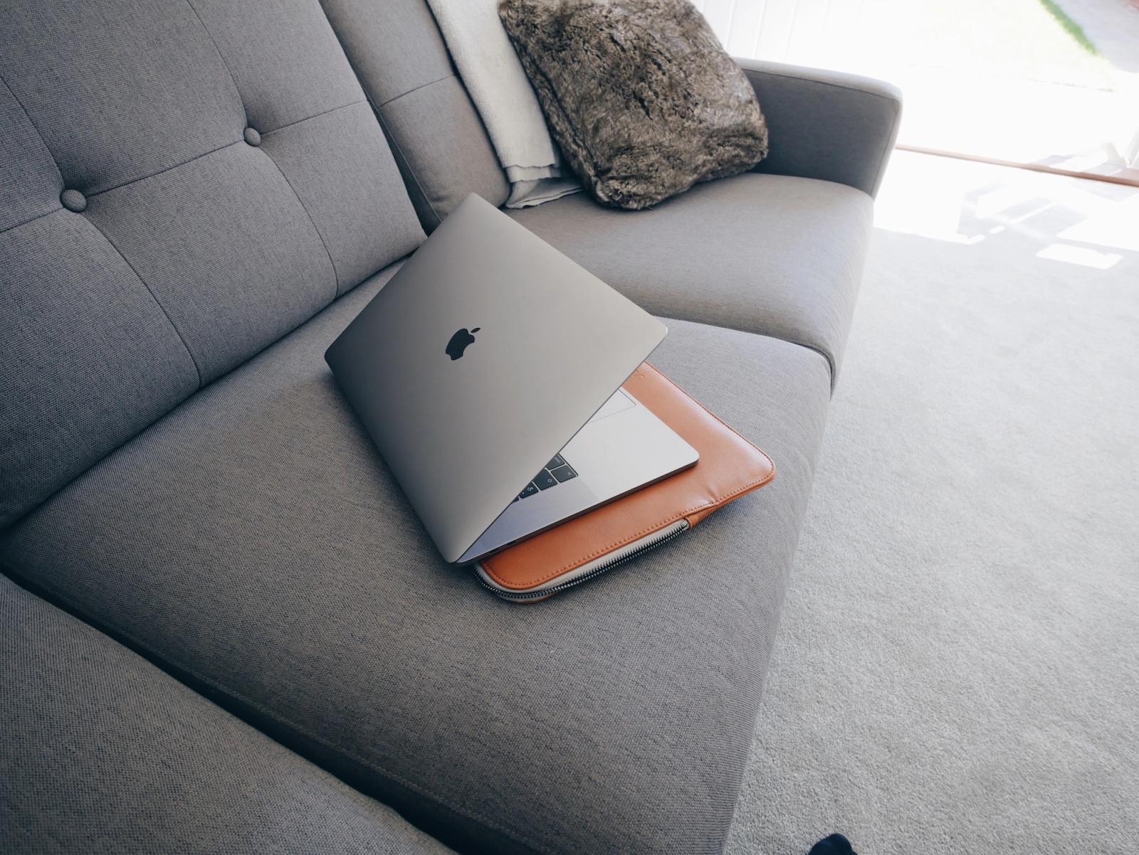 MacBook on a gray couch.