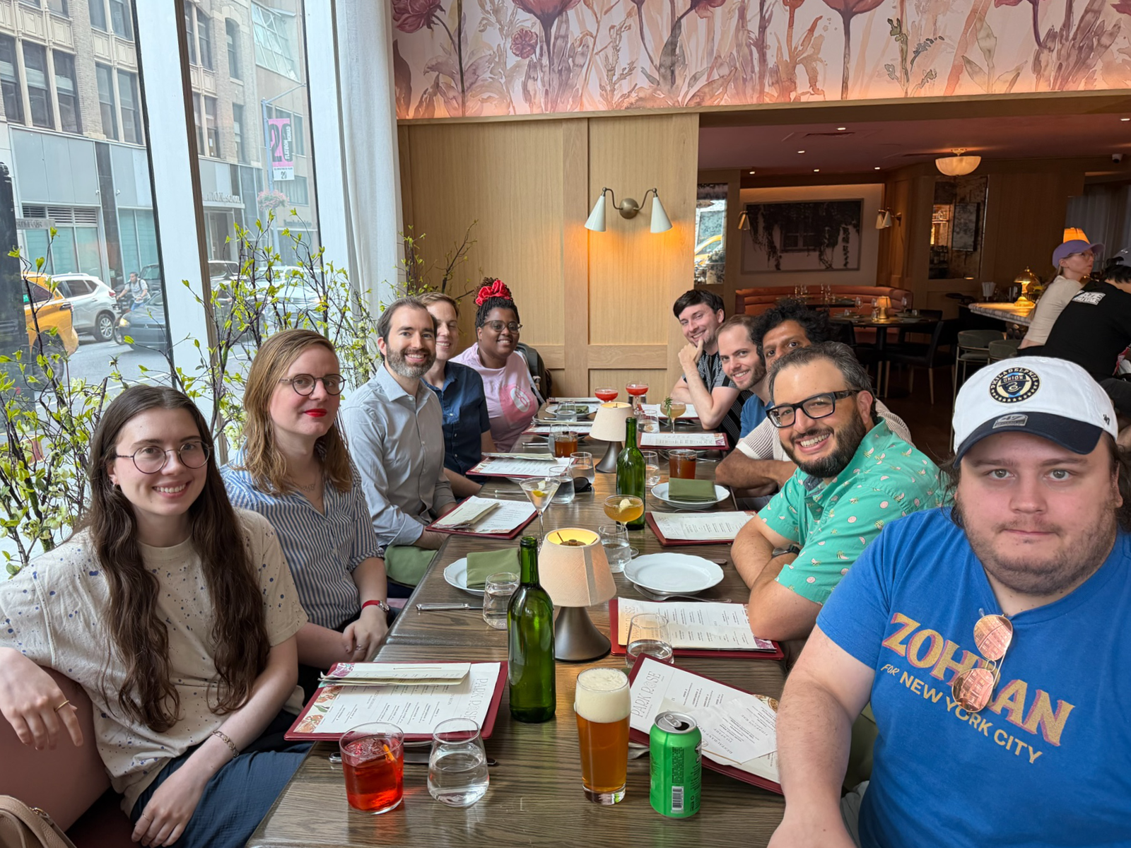 The entire Lickability team sitting at a table with menus and drinks in front of them, posed for a group photo.