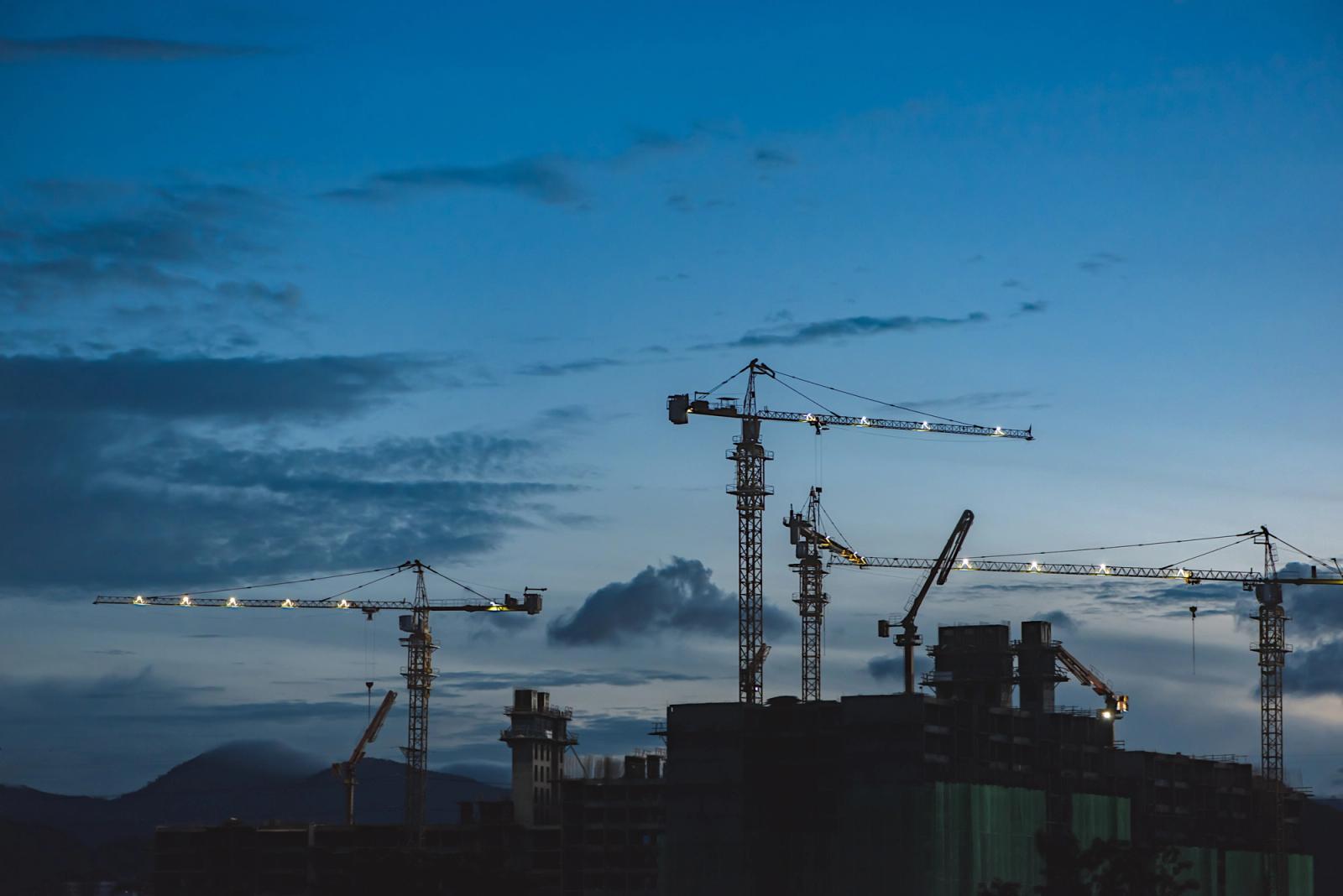 Several cranes above buildings