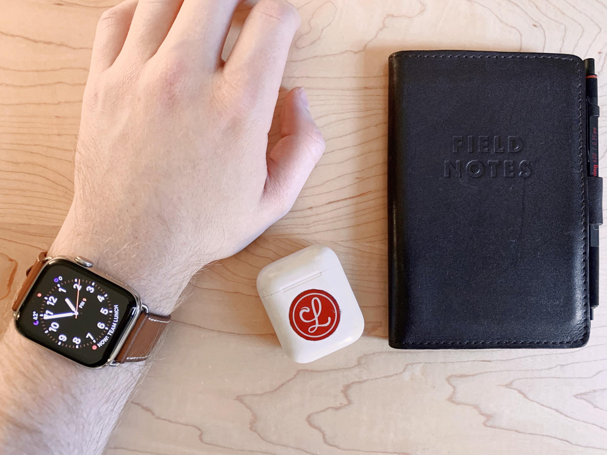 An Apple Watch, AirPods, and Field Notes case.