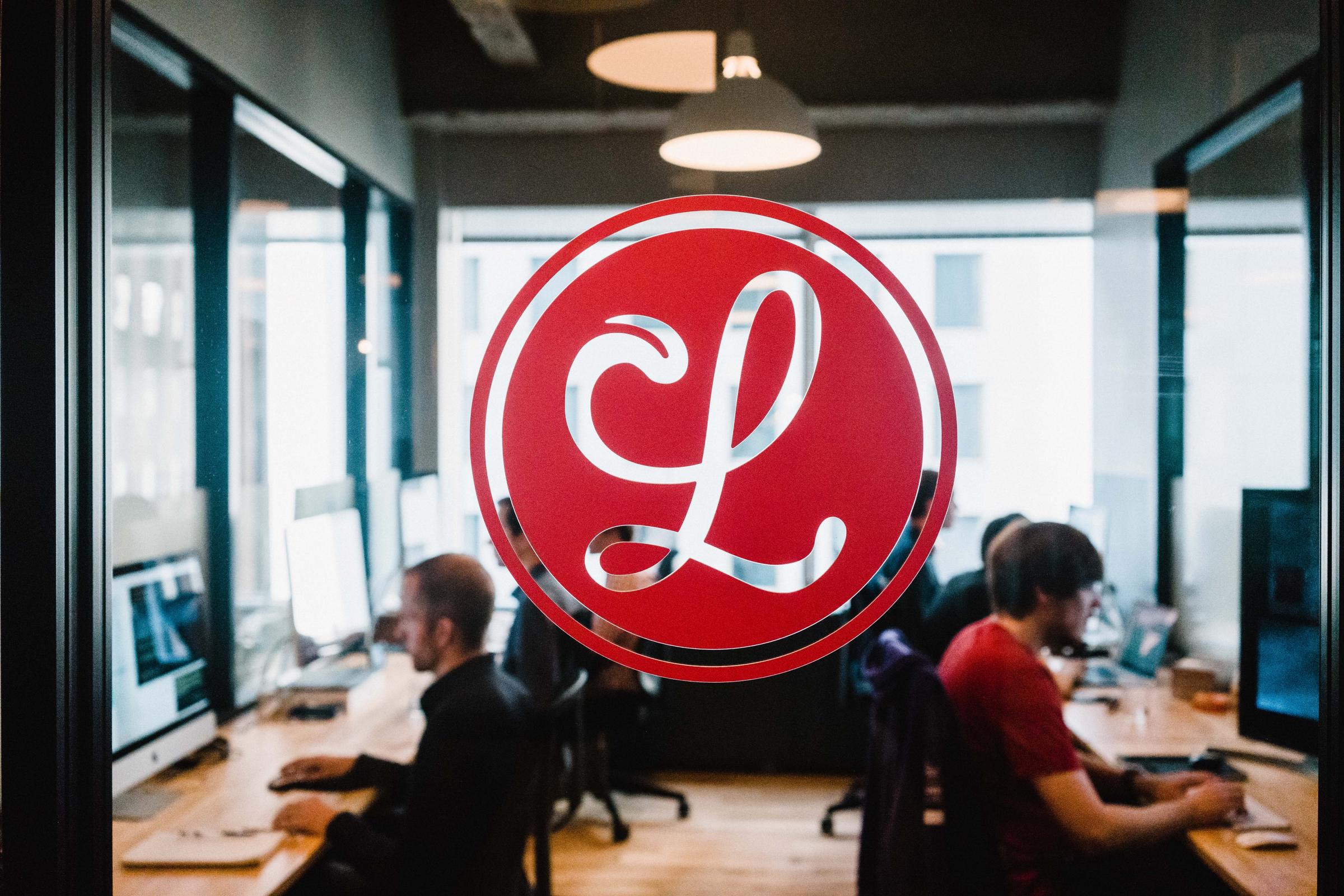 A view of the Lickability office through a glass door displaying the logo.