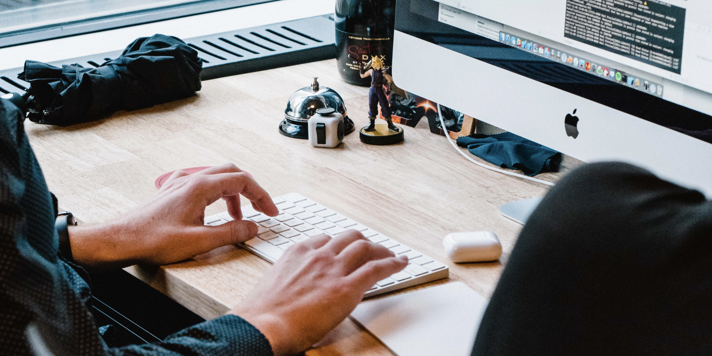 A desk at the Lickability office with two hands typing on a keyboard.