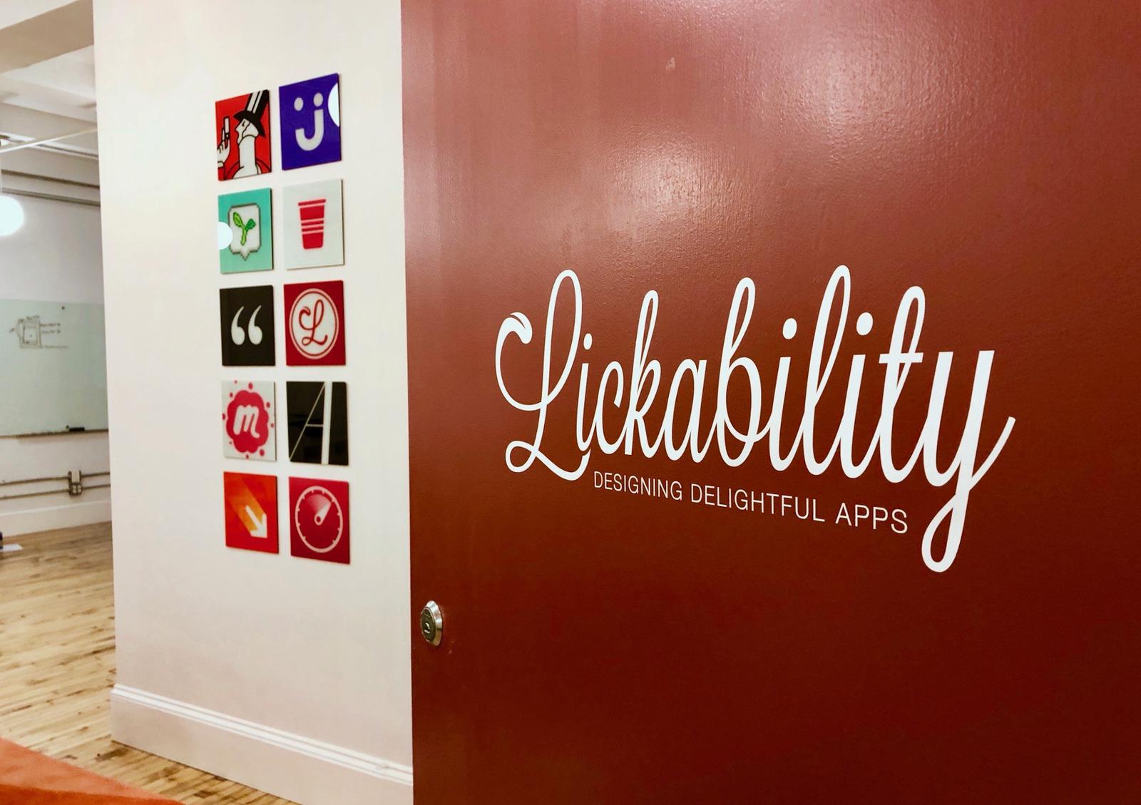 A photograph of the interior of the Lickability office through an open door with the logo.