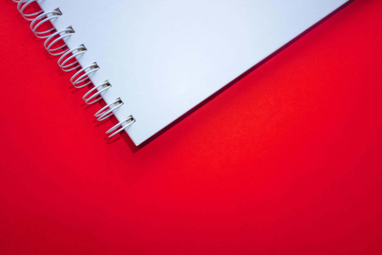 A white notebook on a red background