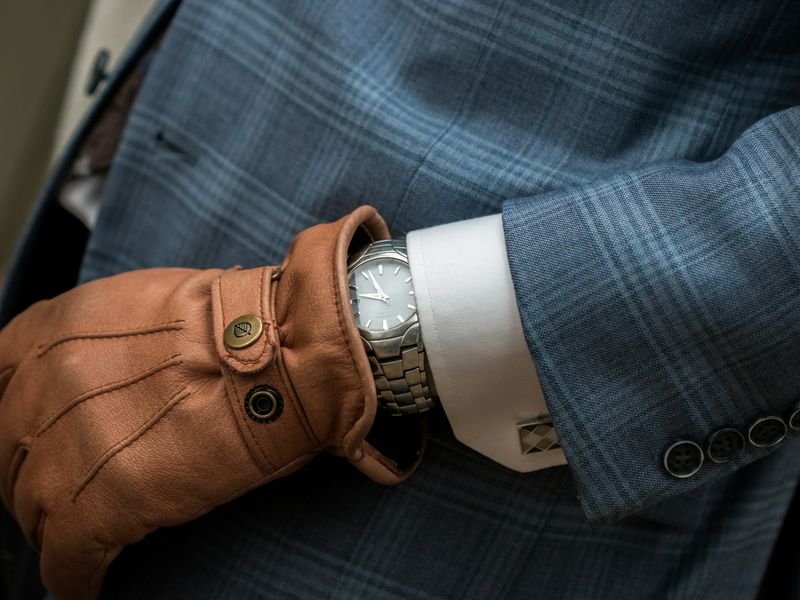 Watch and shirt cuff below a checked jacket sleeve
