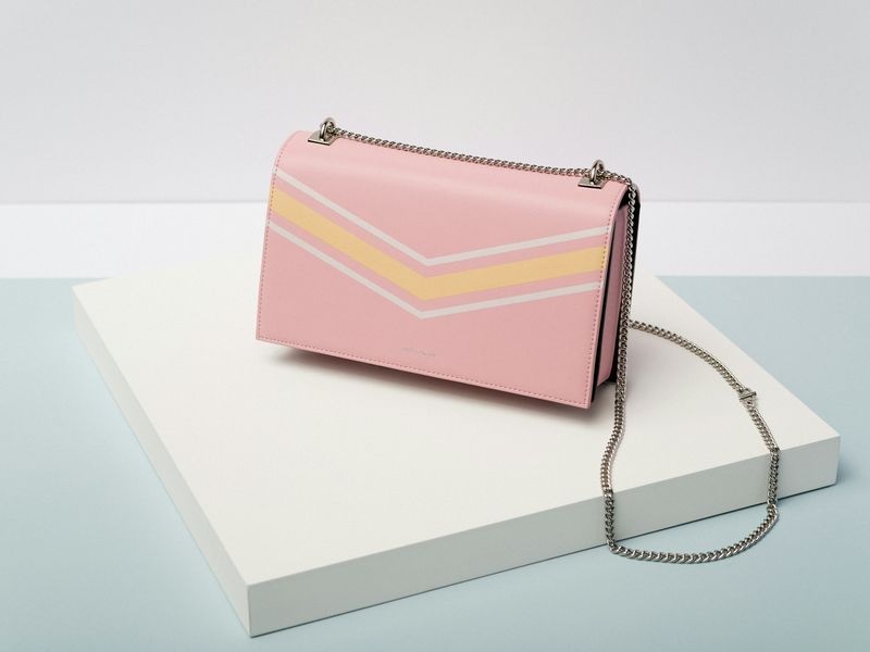Pale pink chain bag displayed on a white plinth
