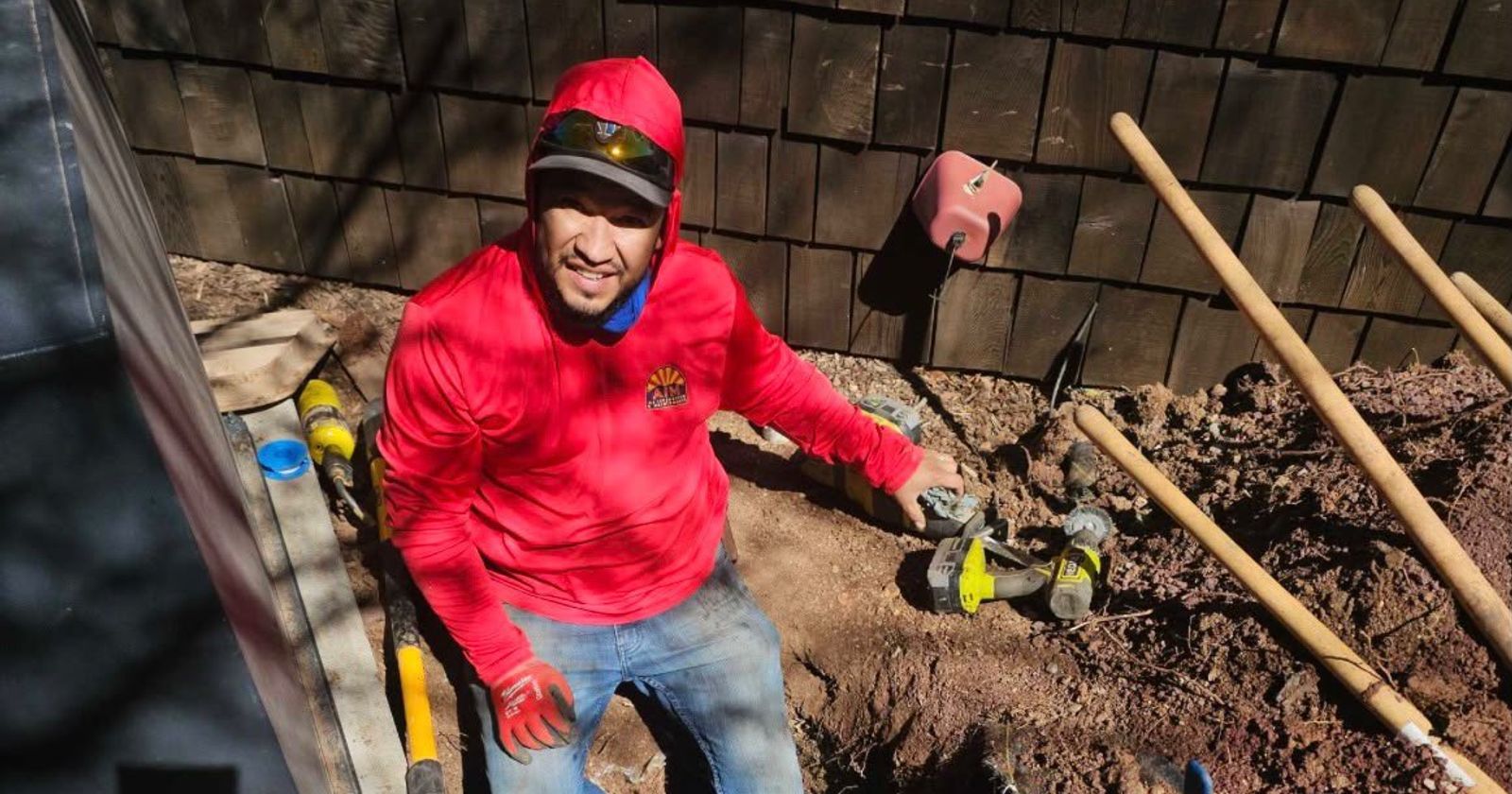 An AZ Irrigation technician repairing irrigation pipe in an open trench