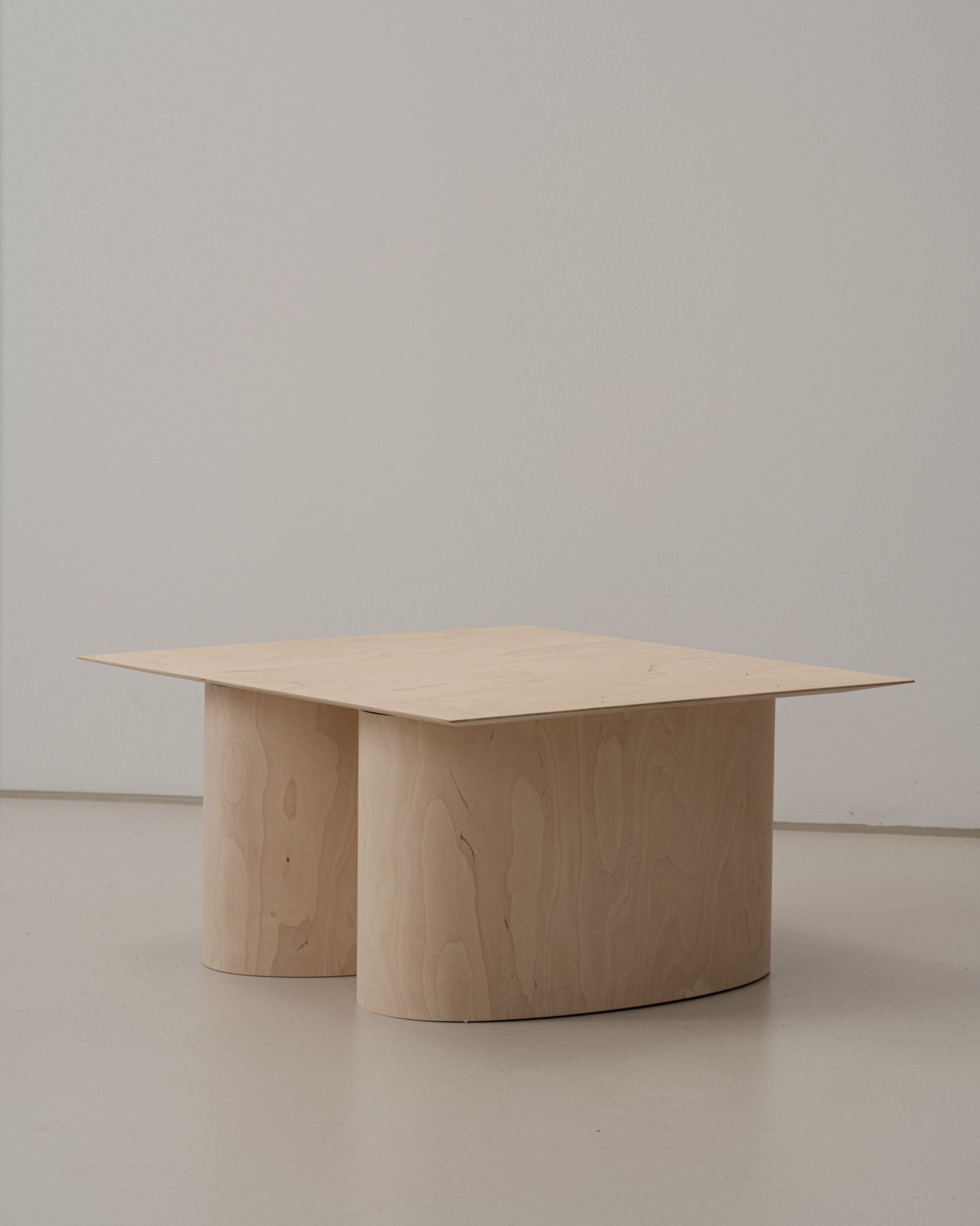 Low coffee table with steam-bent oval plywood legs and a beveled, thin-profile top