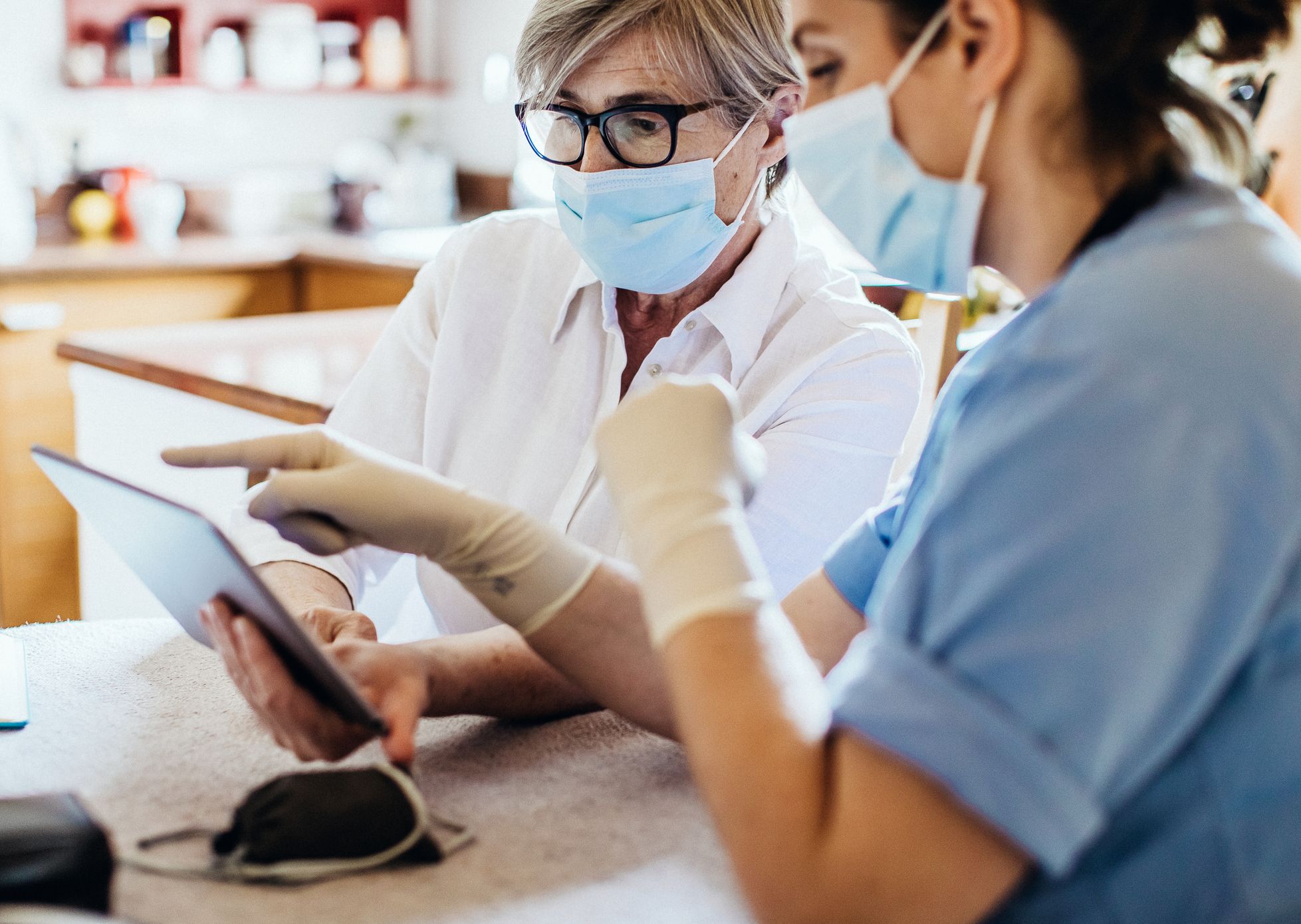 Medical professionals in masks looking at tablet