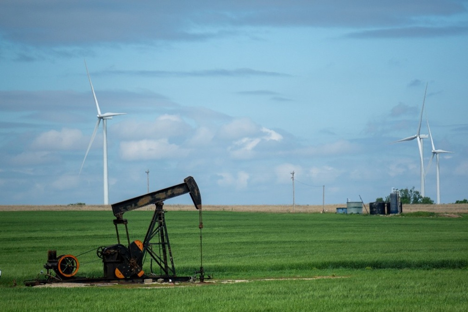 Image of wind farms beside a pumpjack in Western Canada