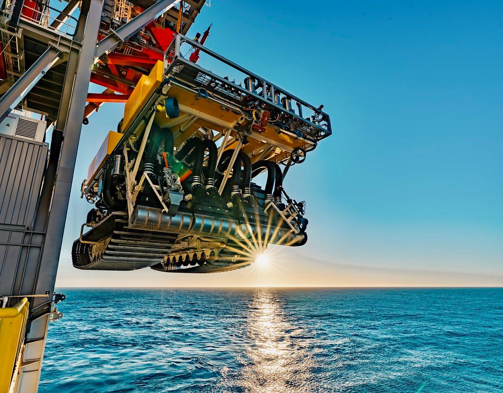 Image of a deep-sea mining truck about to be lowered into the water
