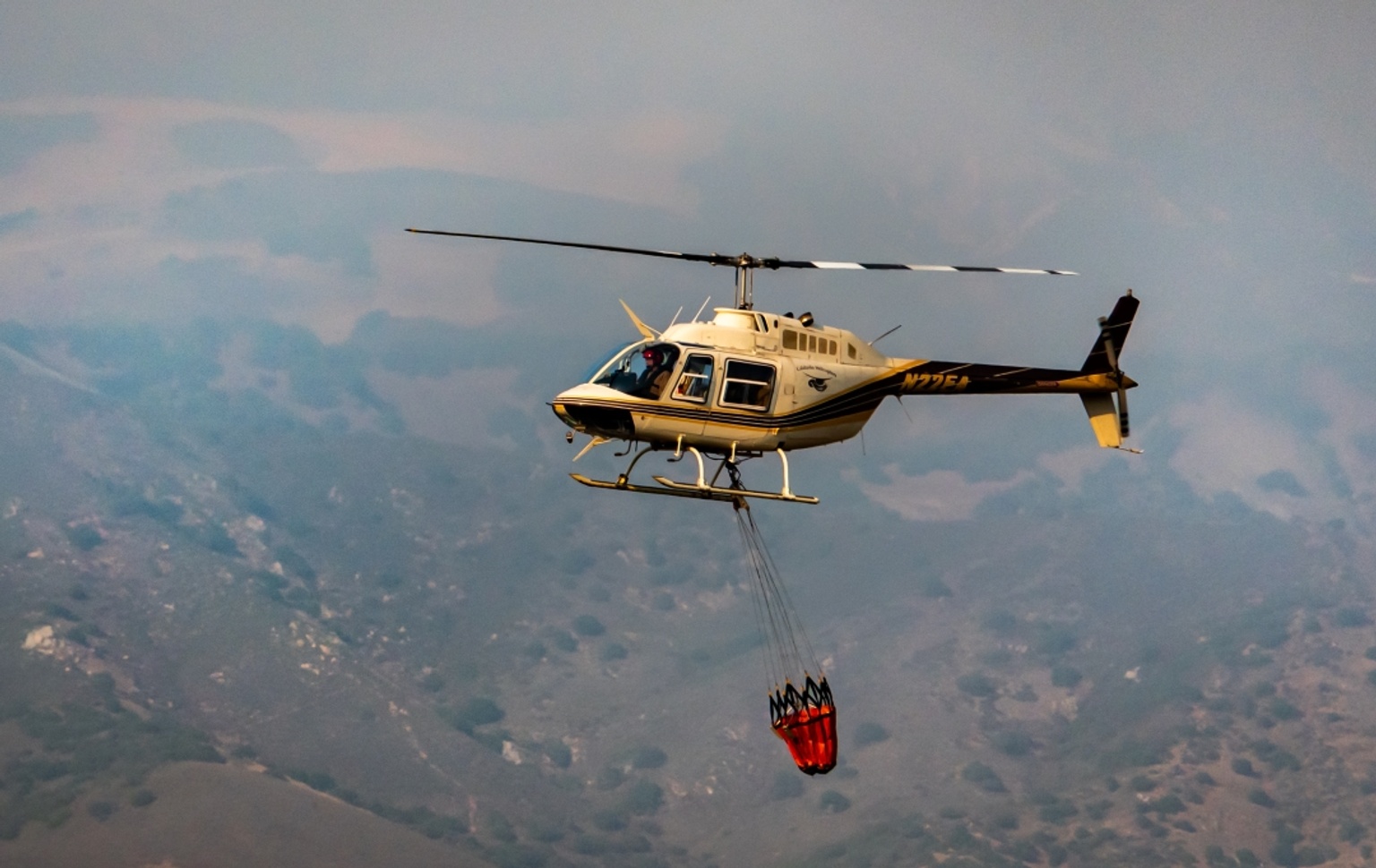 helicopter carrying bucket of water